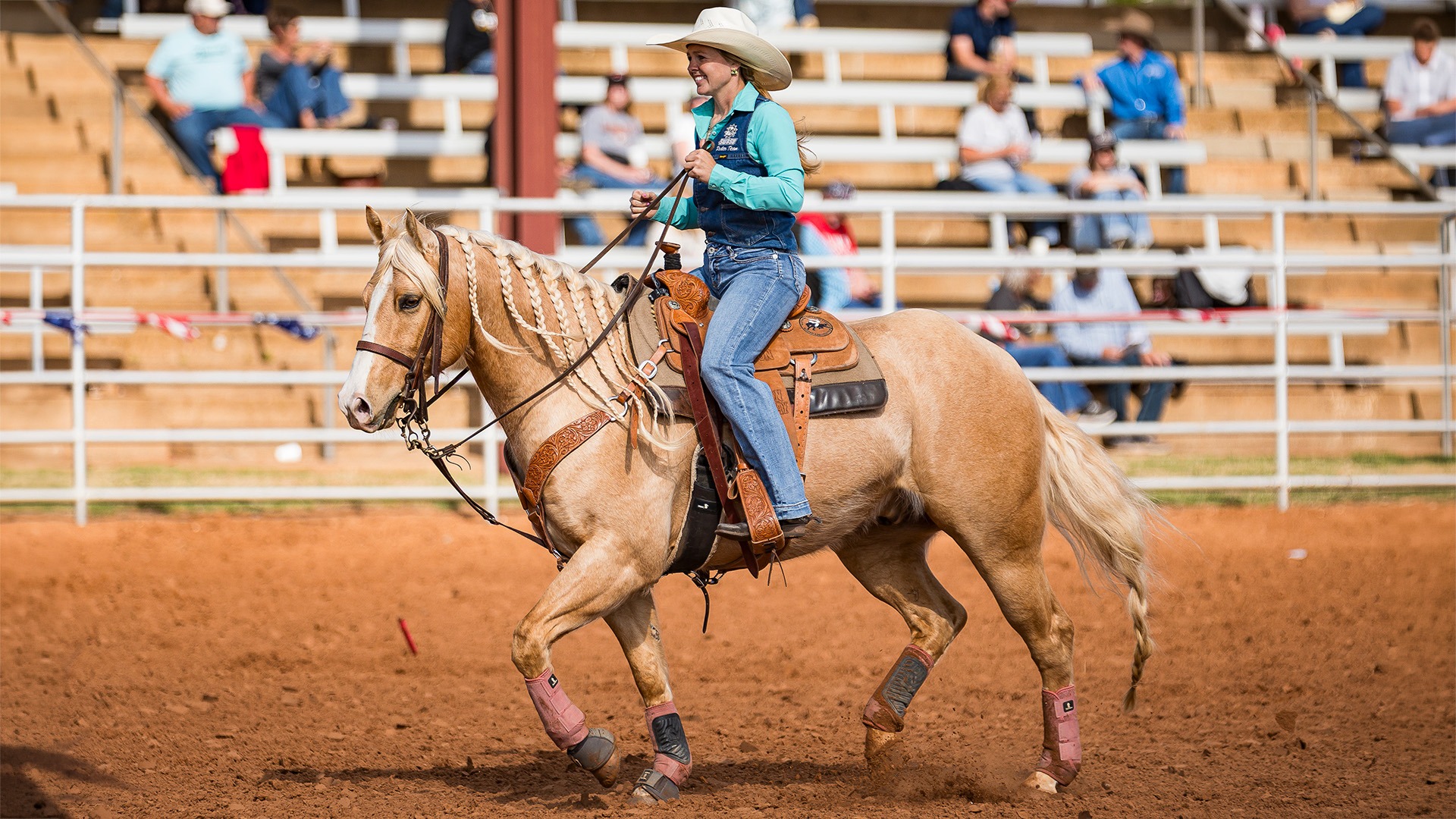 swosu rodeo team member rides a horse in the arena