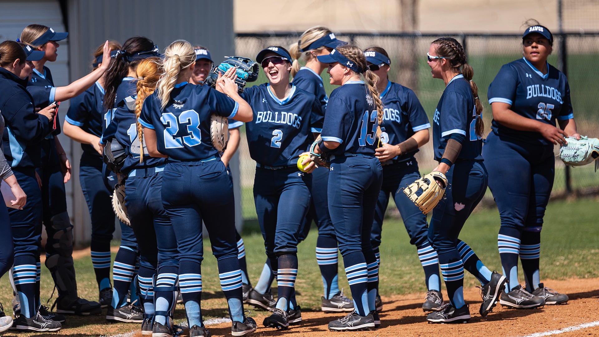 Sierra Woods celebrates in a huddle after the third out of the inning on defense