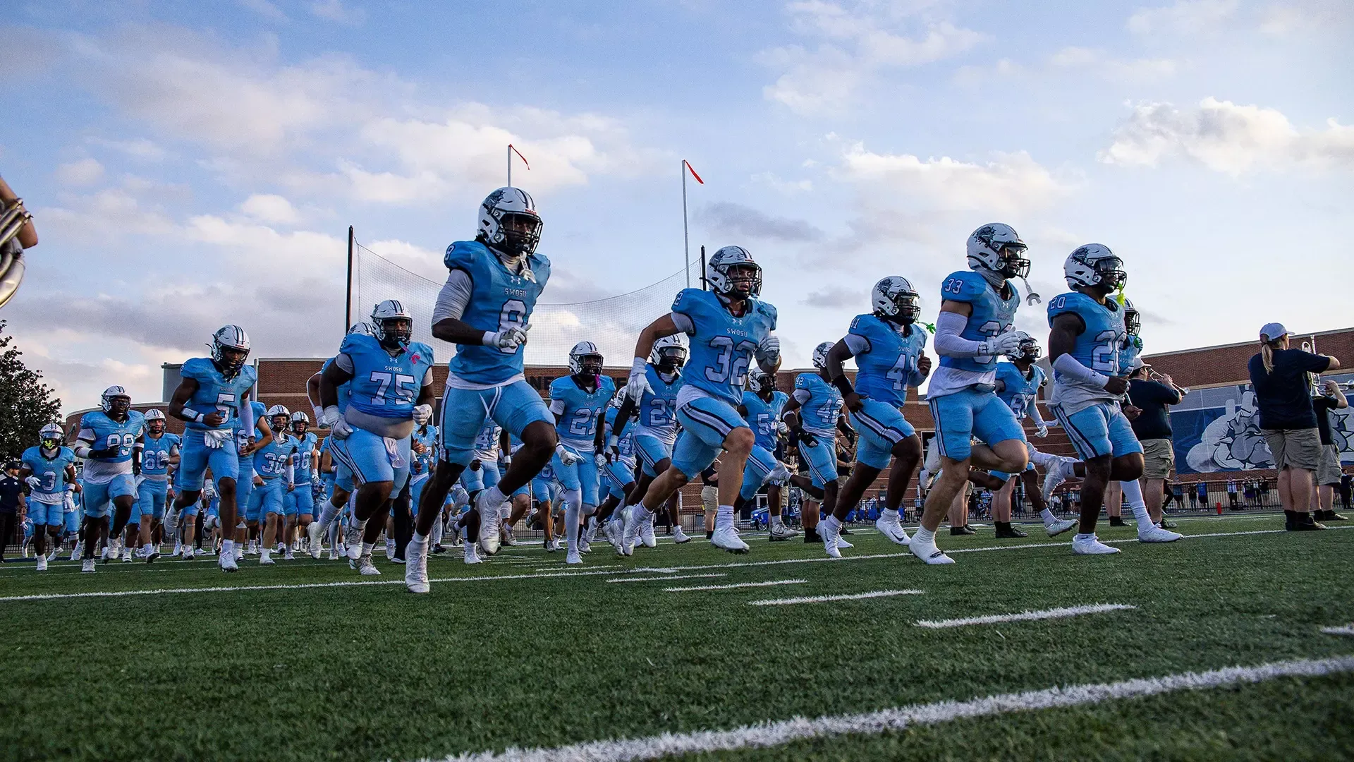 SWOSU Football runs onto the field getting ready to start a game