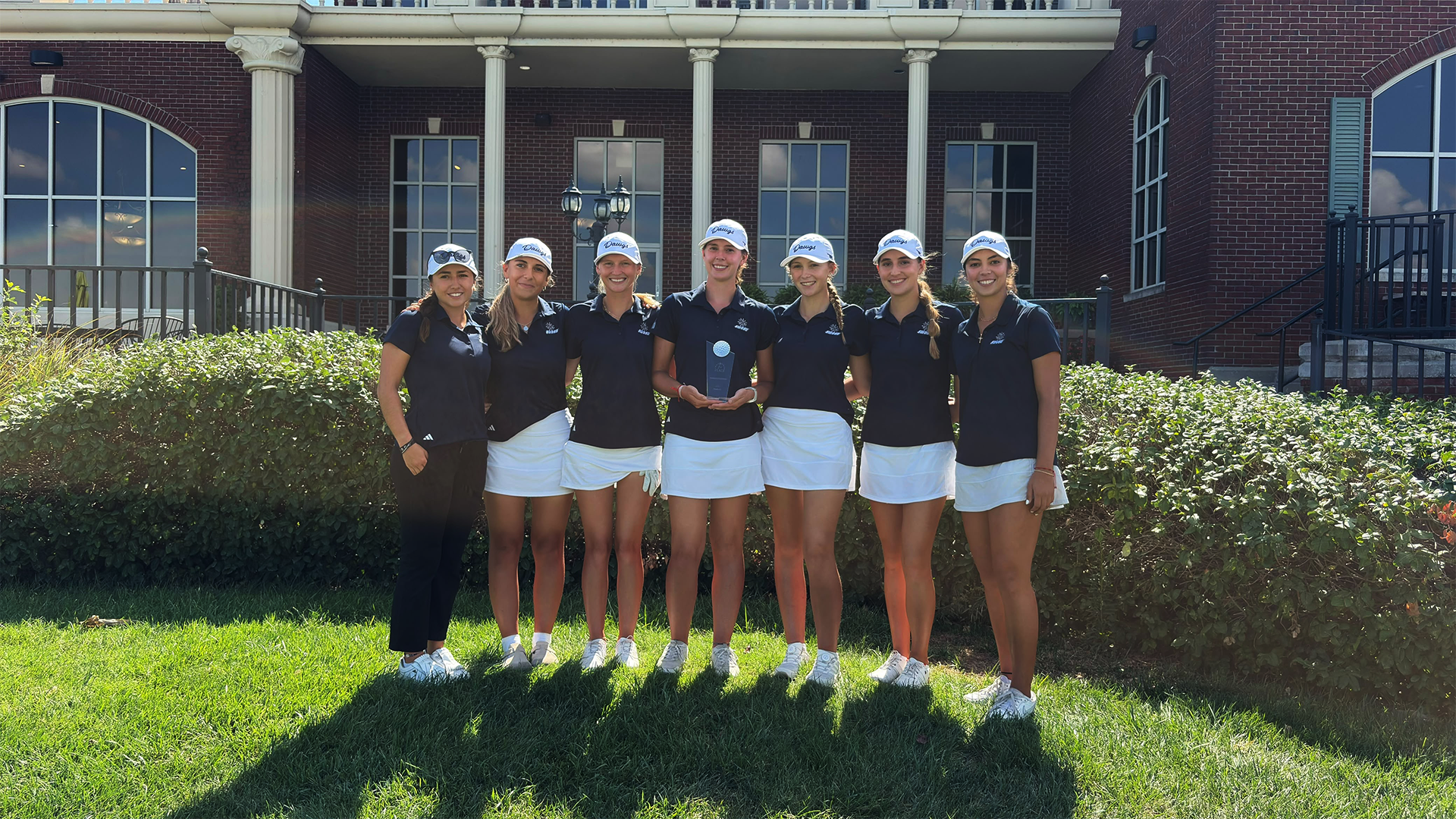 Lady Bulldog Golf team holds trophy after winning Newman Invitational