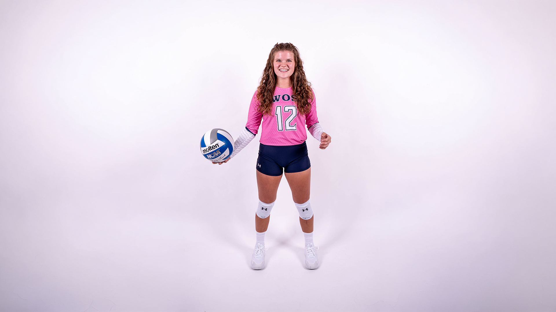 Willow Deckinger smiles with a volleyball in a posed shot on media day