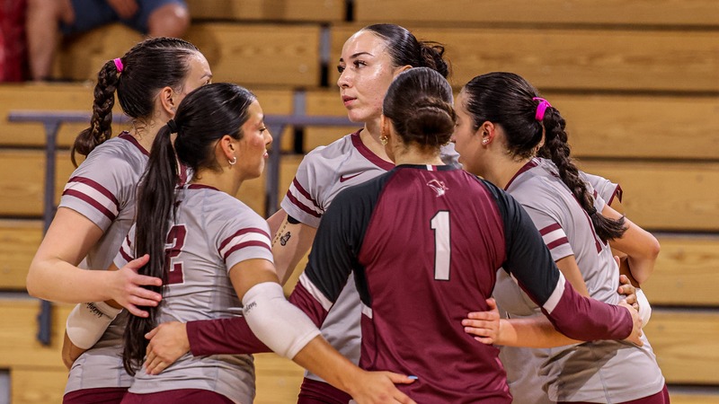 The Volleyball team huddles together during a match