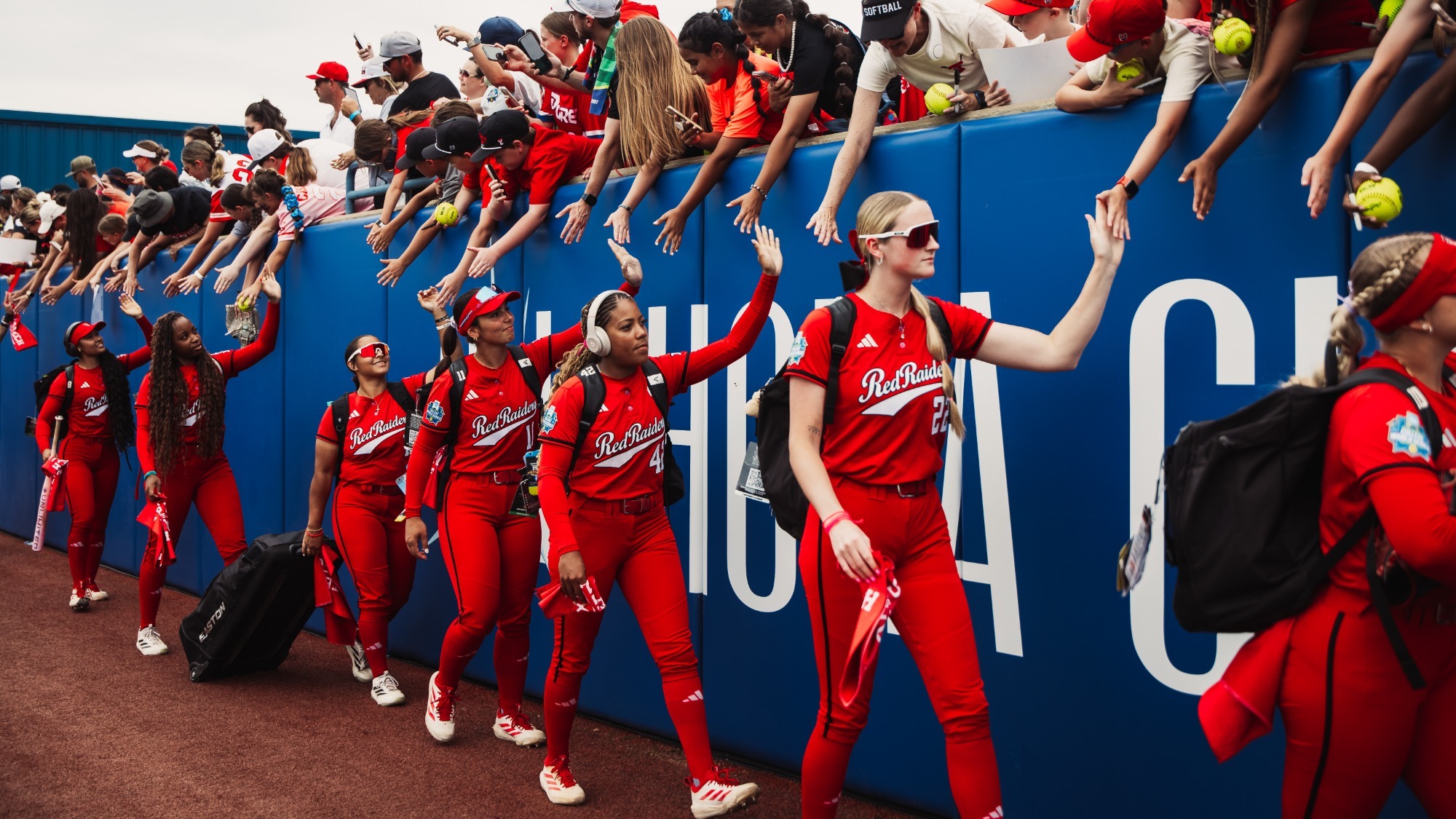 Texas Tech softball players greet fans before a Women's College World Series game