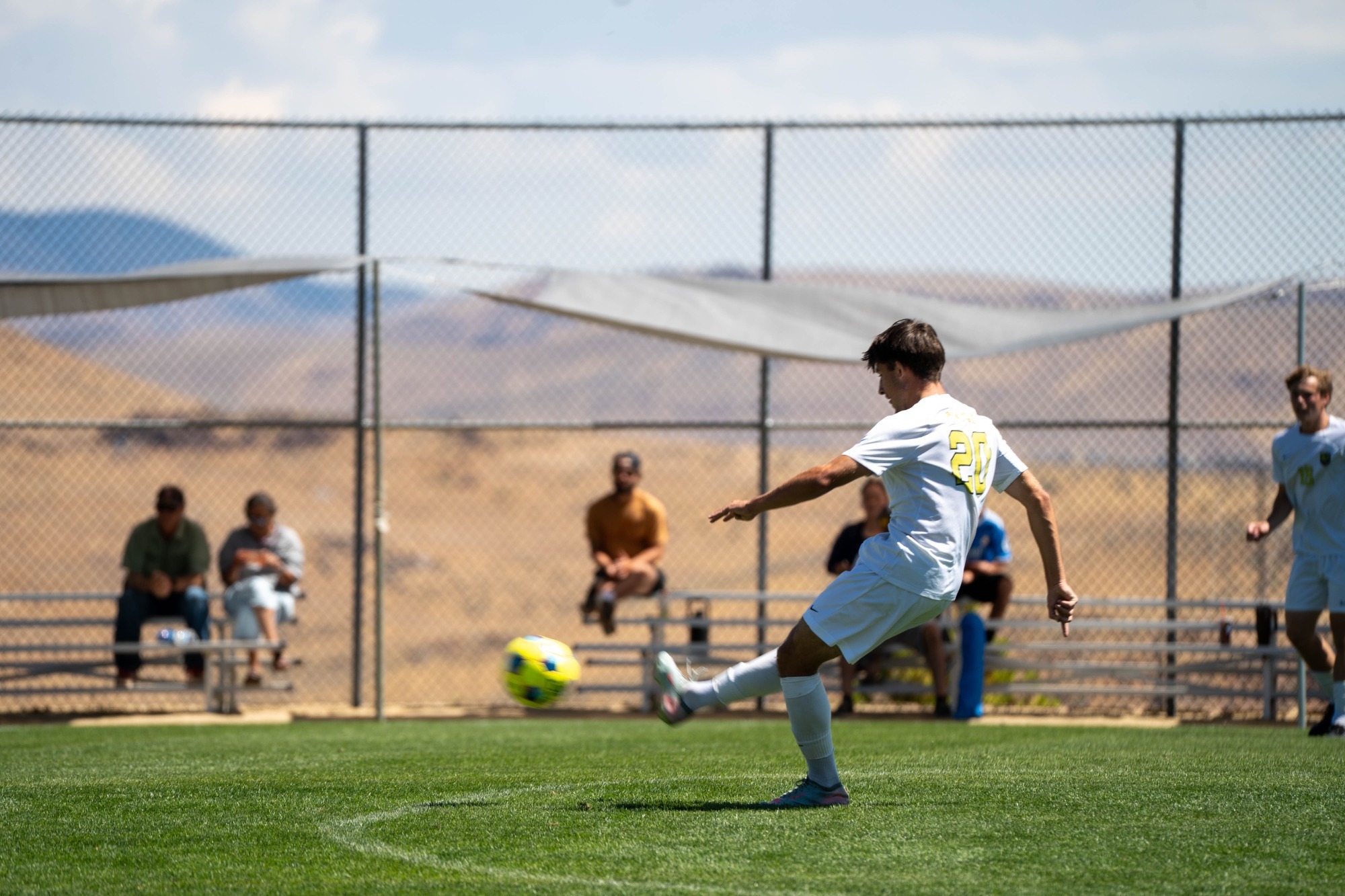 Men's soccer player number 20 Trevan O'Brien kicking the ball up the field