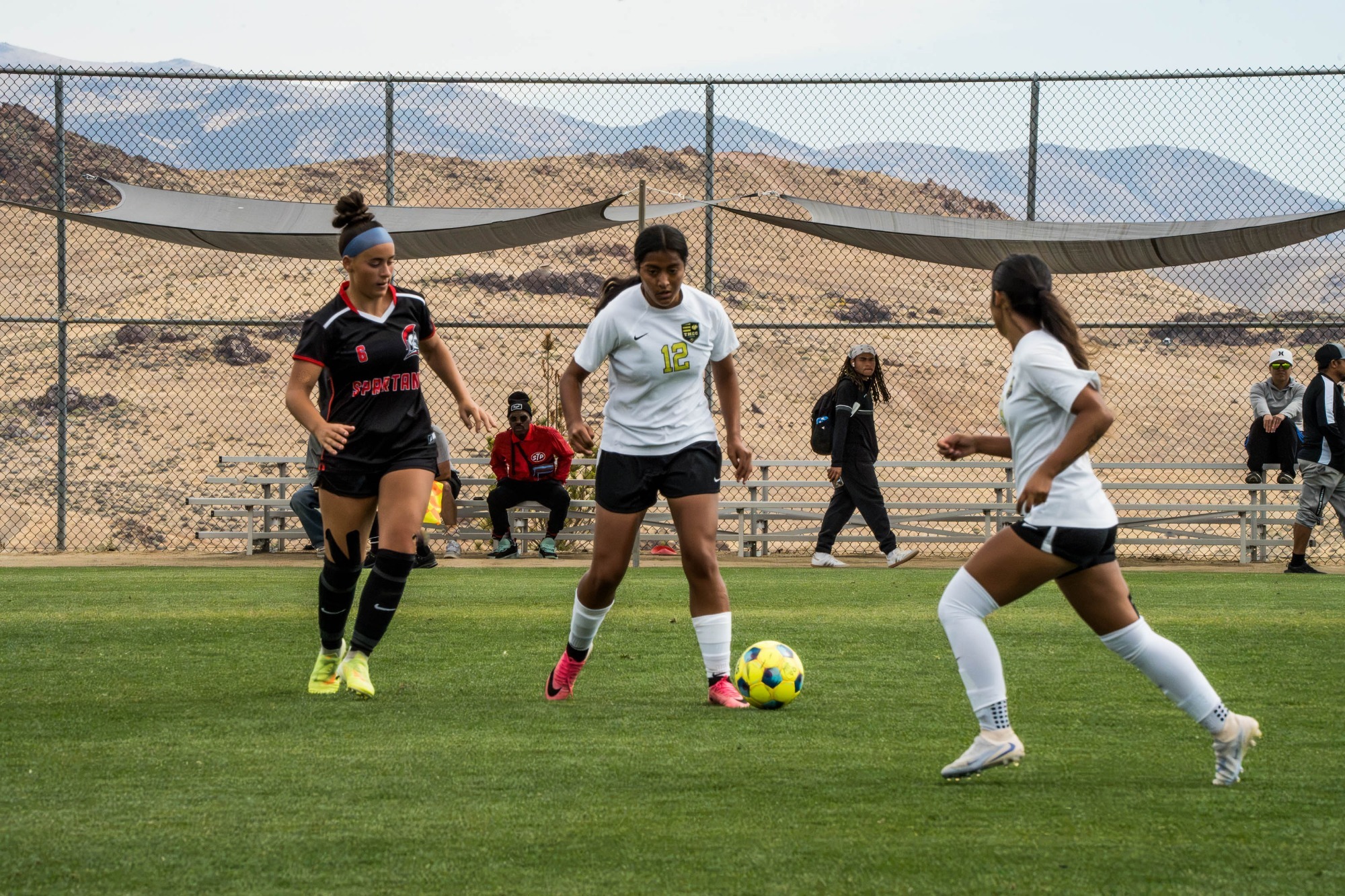 Sherly Ramirez (#12) prepares to pass the ball to Jocelyn Lopez as she makes a run up the field.