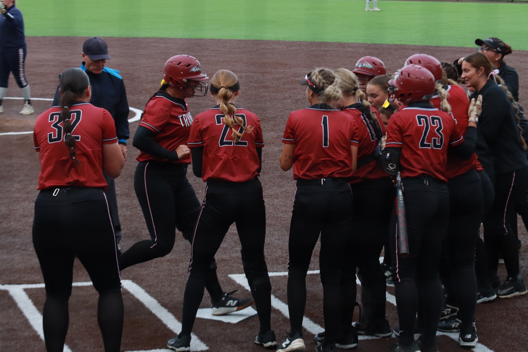 Transylvania celebrates at home plate as Raegan Gibson (#44) scores a two run home run. 
