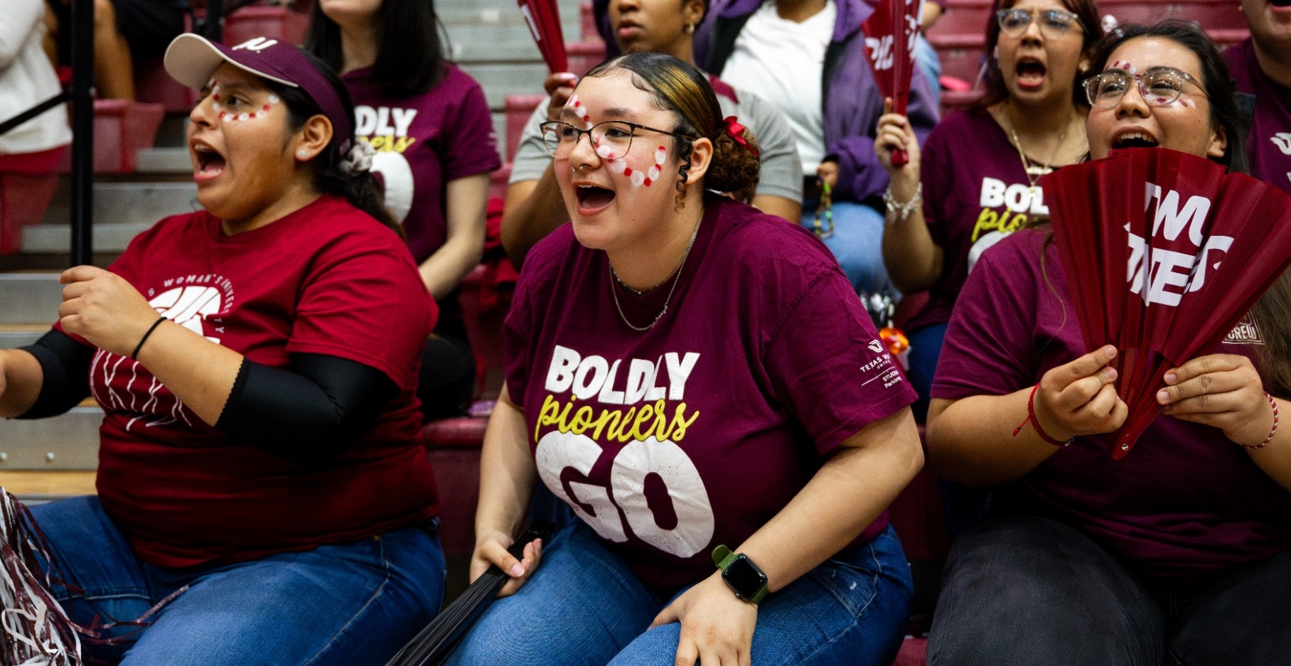 Fans cheer at TWU Basketball. 