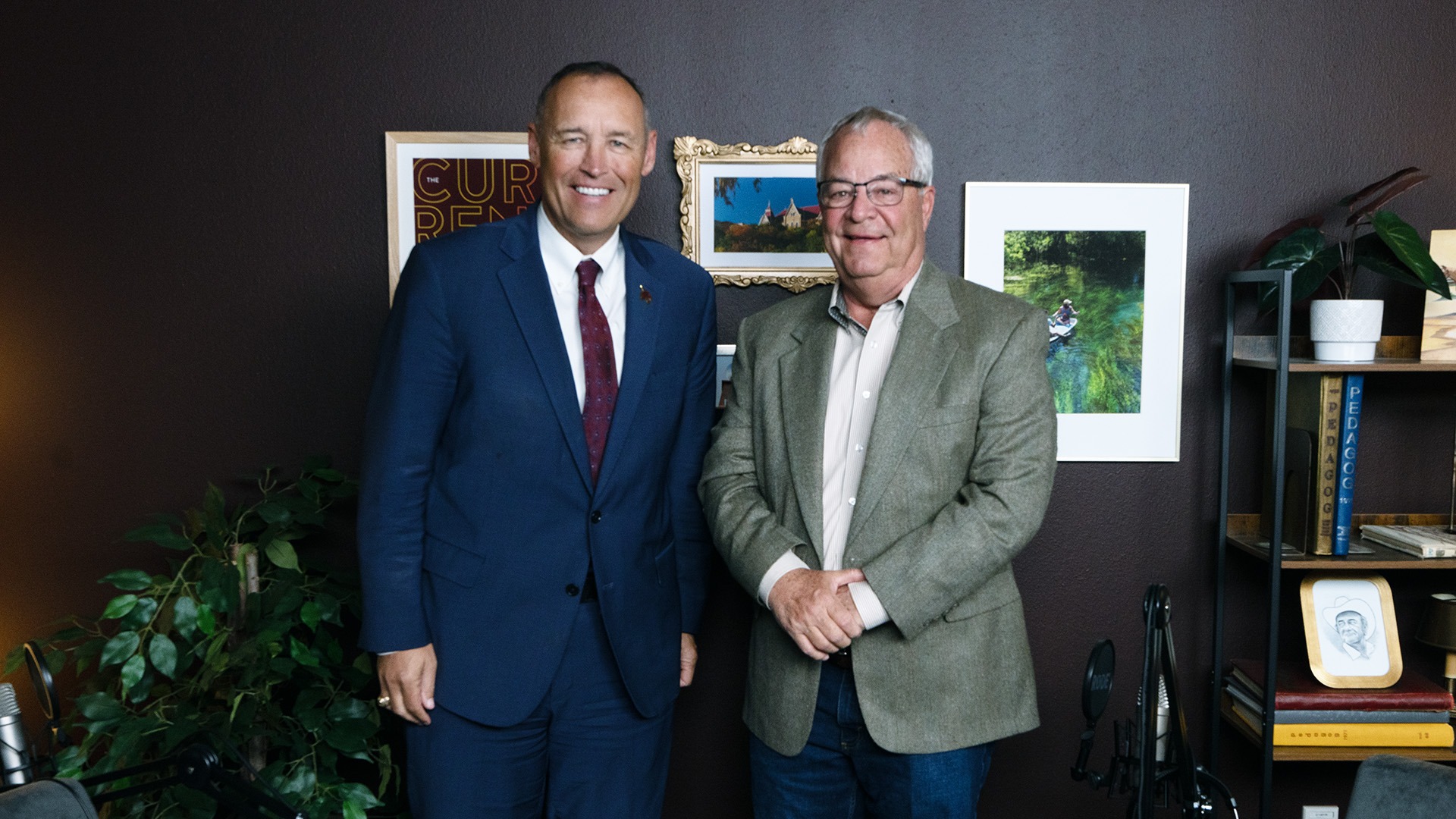 Texas State University President Kelly Damphousse poses for a photo with Bobcat superfan Tom Madden on the set of The Current podcast.