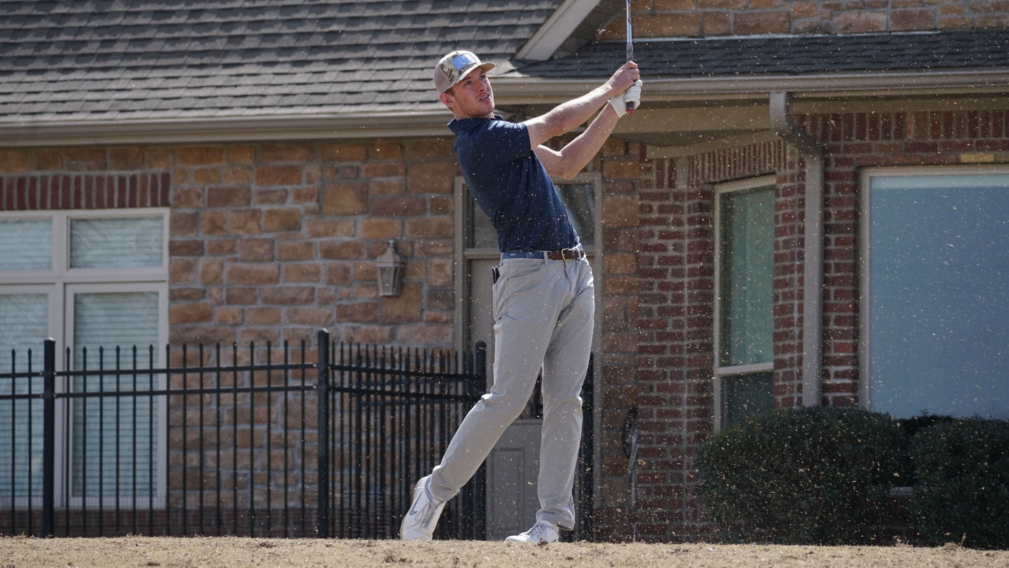 A men's golfer takes a swing during a tournament. 