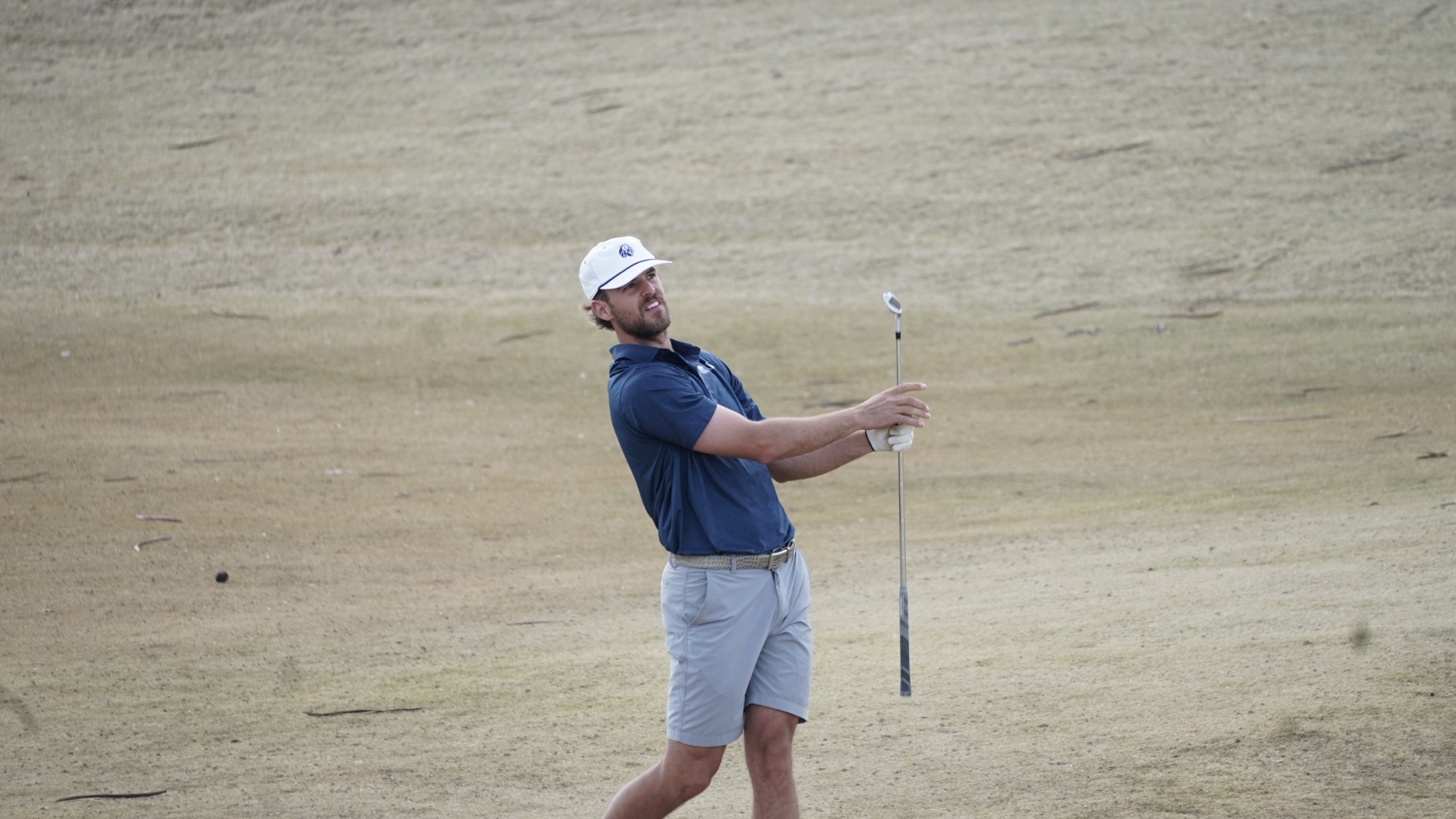 A men's golfer takes a swing during a tournament. 
