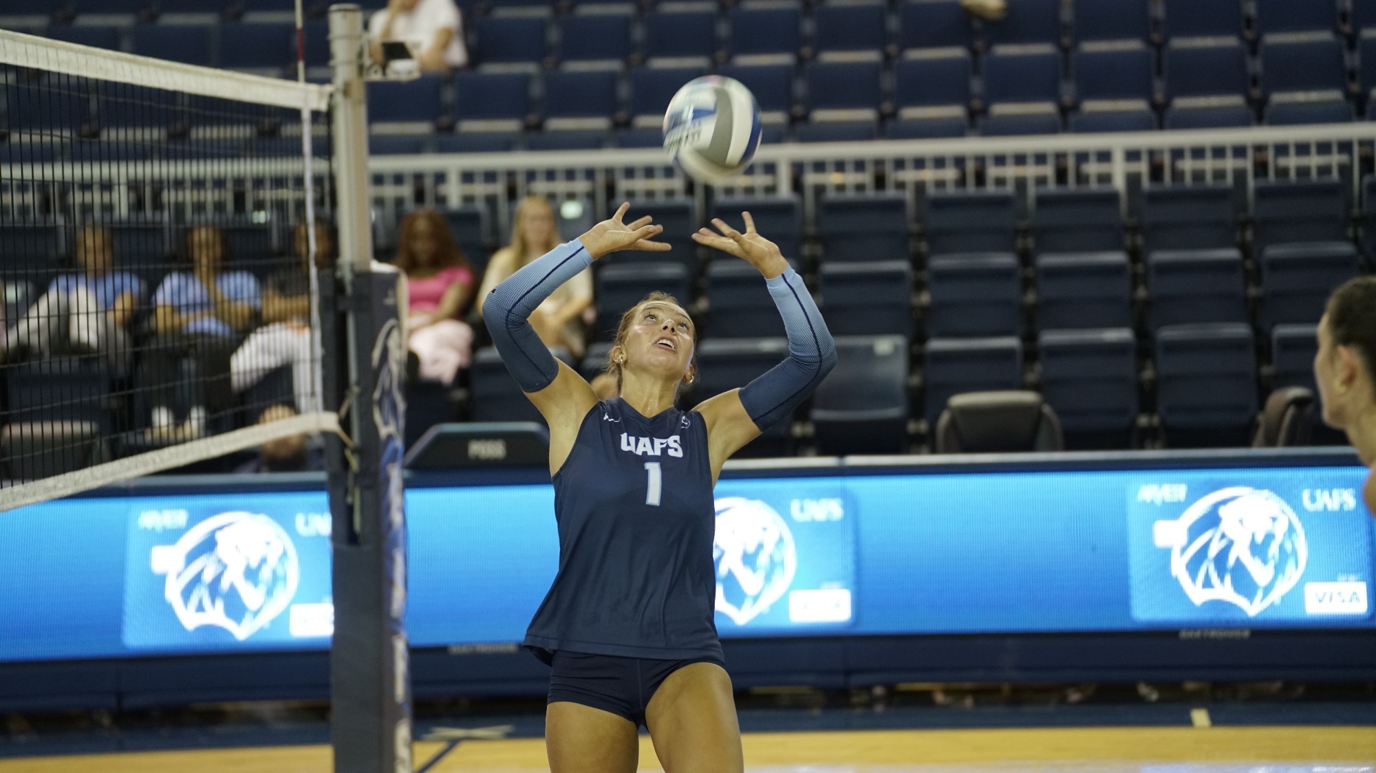 A volleyball player sets the ball. 