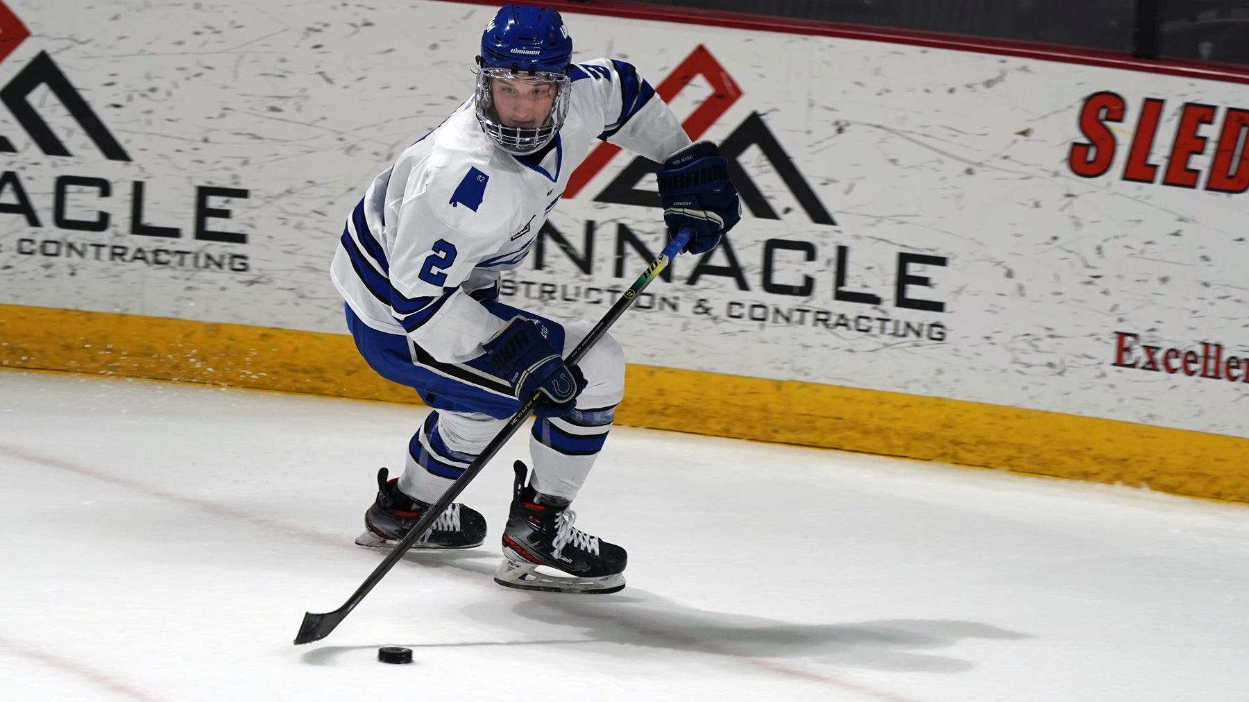 Lucas Bahn skates with the puck in the Chargers defensive end during a game at the Von Braun Center. He wears a white jersey, blue pants and a blue helmet.
