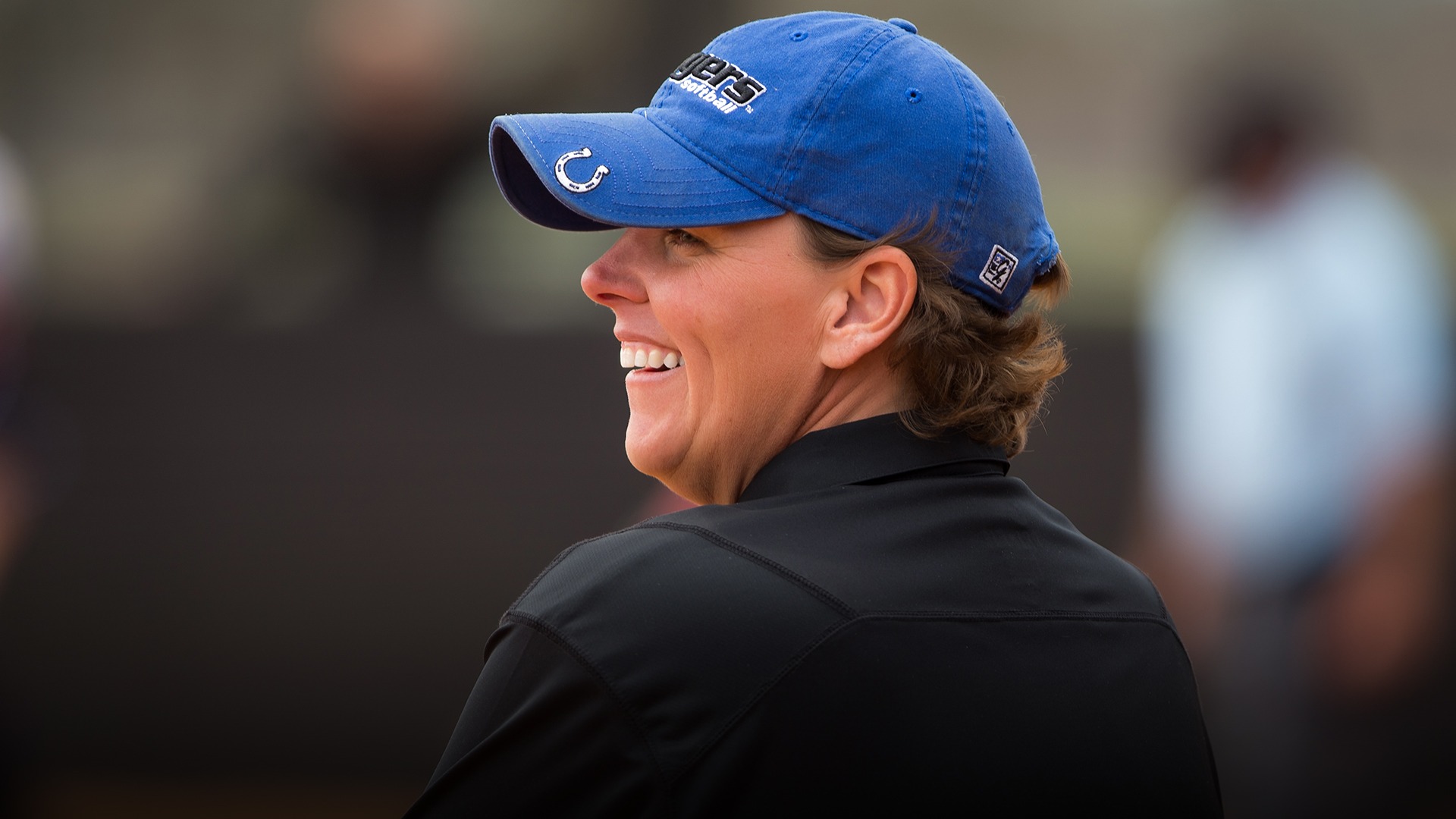 Les Stuedeman similing with a blue hat and black polo at a U A H softball game