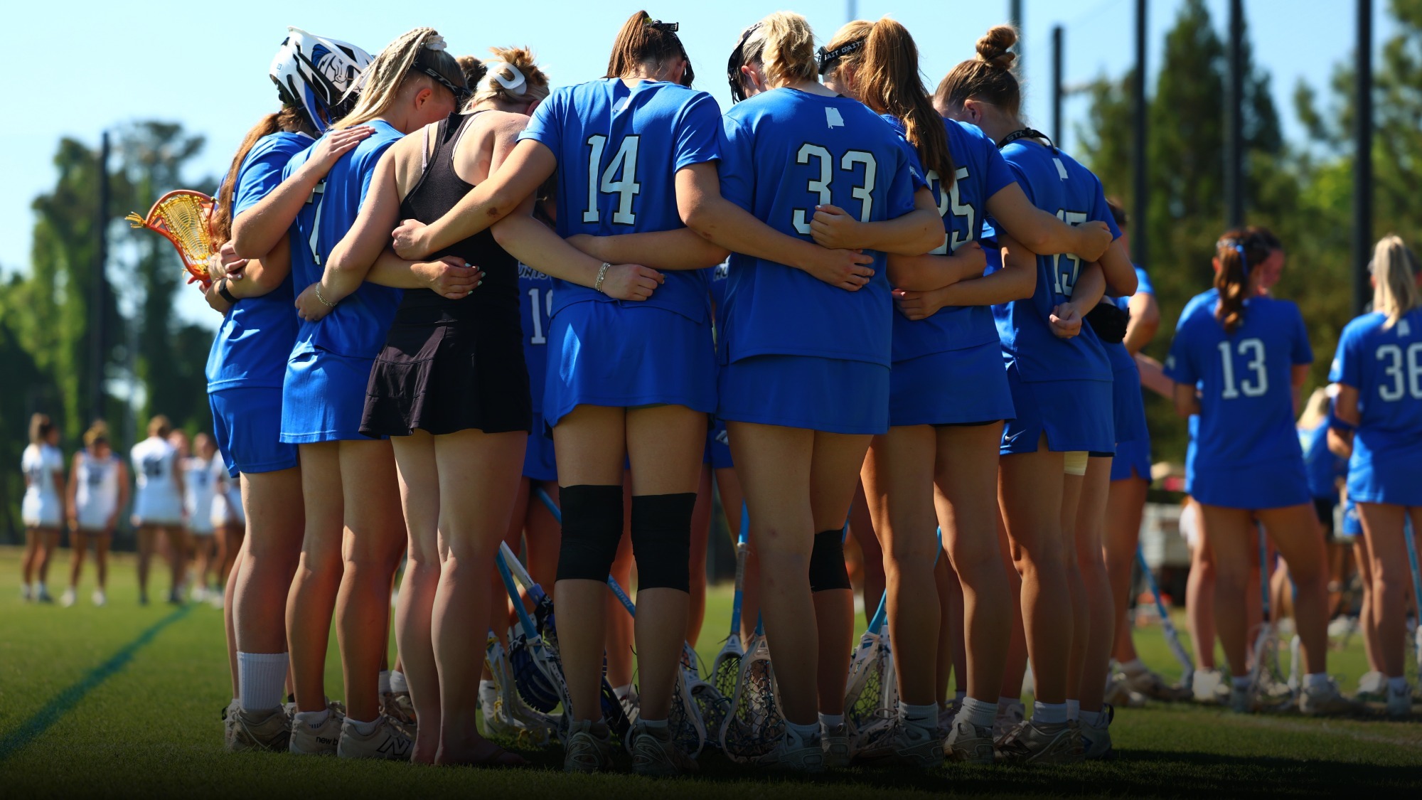 Women's lacrosse team huddled pre-game
