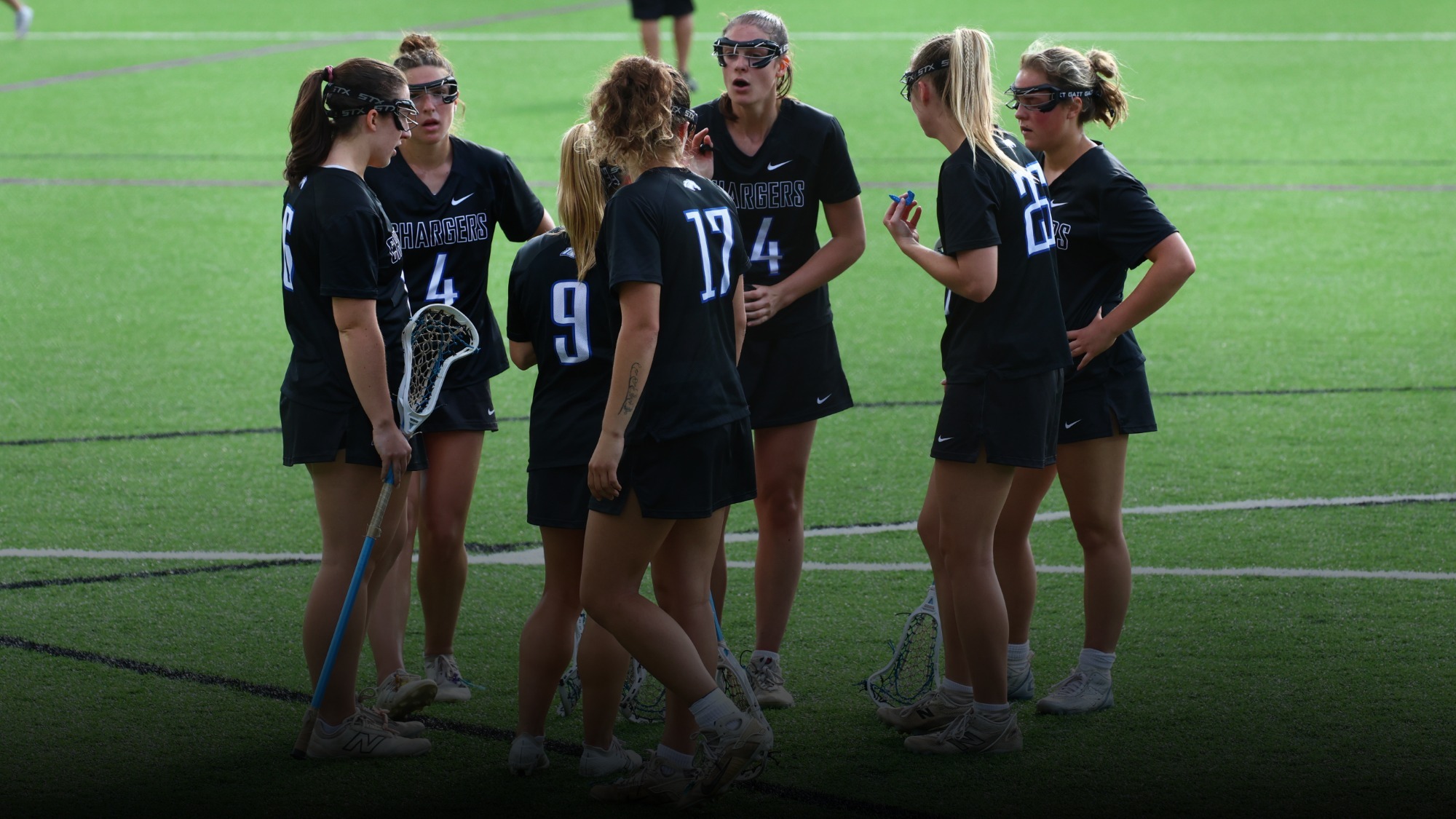 UAH women's lacrosse players huddling after a goal