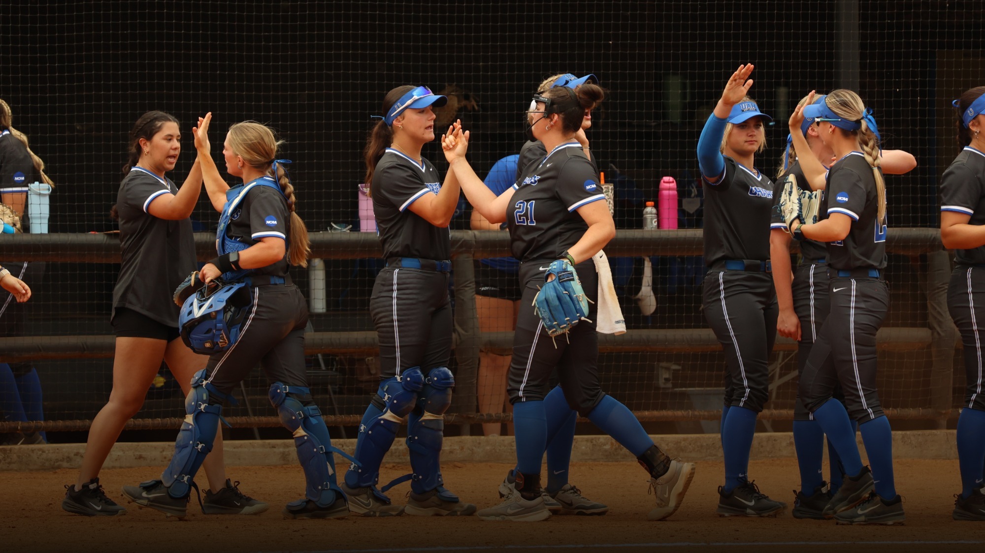 UAH Softball players high fiving after an inning