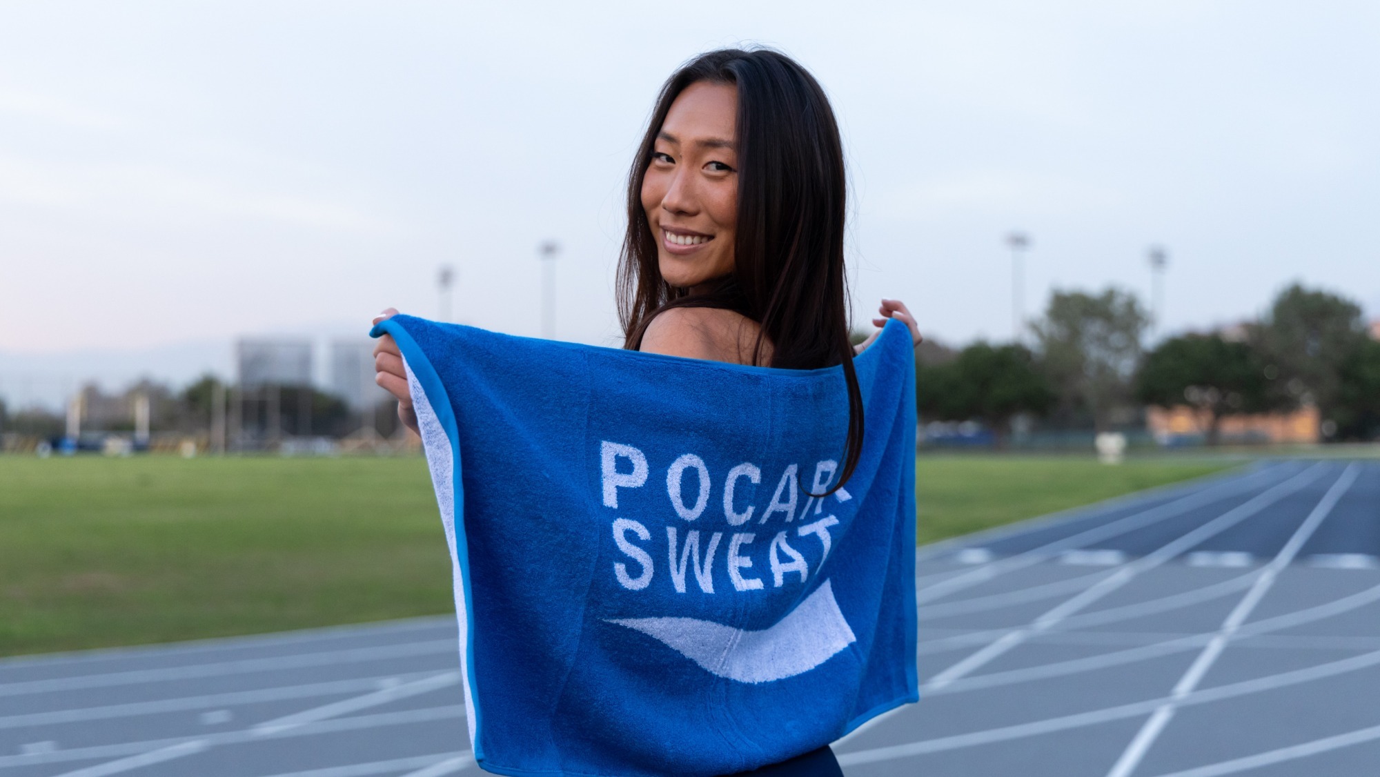 Anna Vogtmann poses with a Pocari Sweat towel at Anteater Stadium
