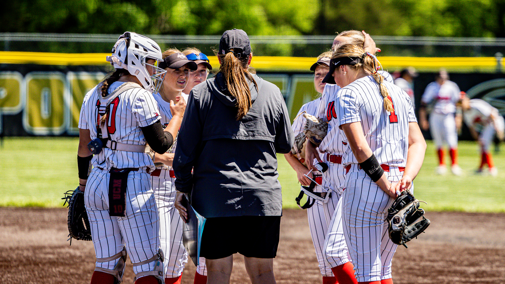 Susan Anderson with team talking at 2026 MIAA Softball Championship Quarterfinal vs ESU