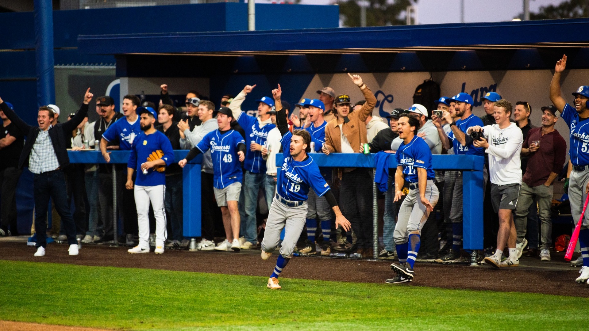Alumni celebrate an RBI hit during the 2025 alumni game