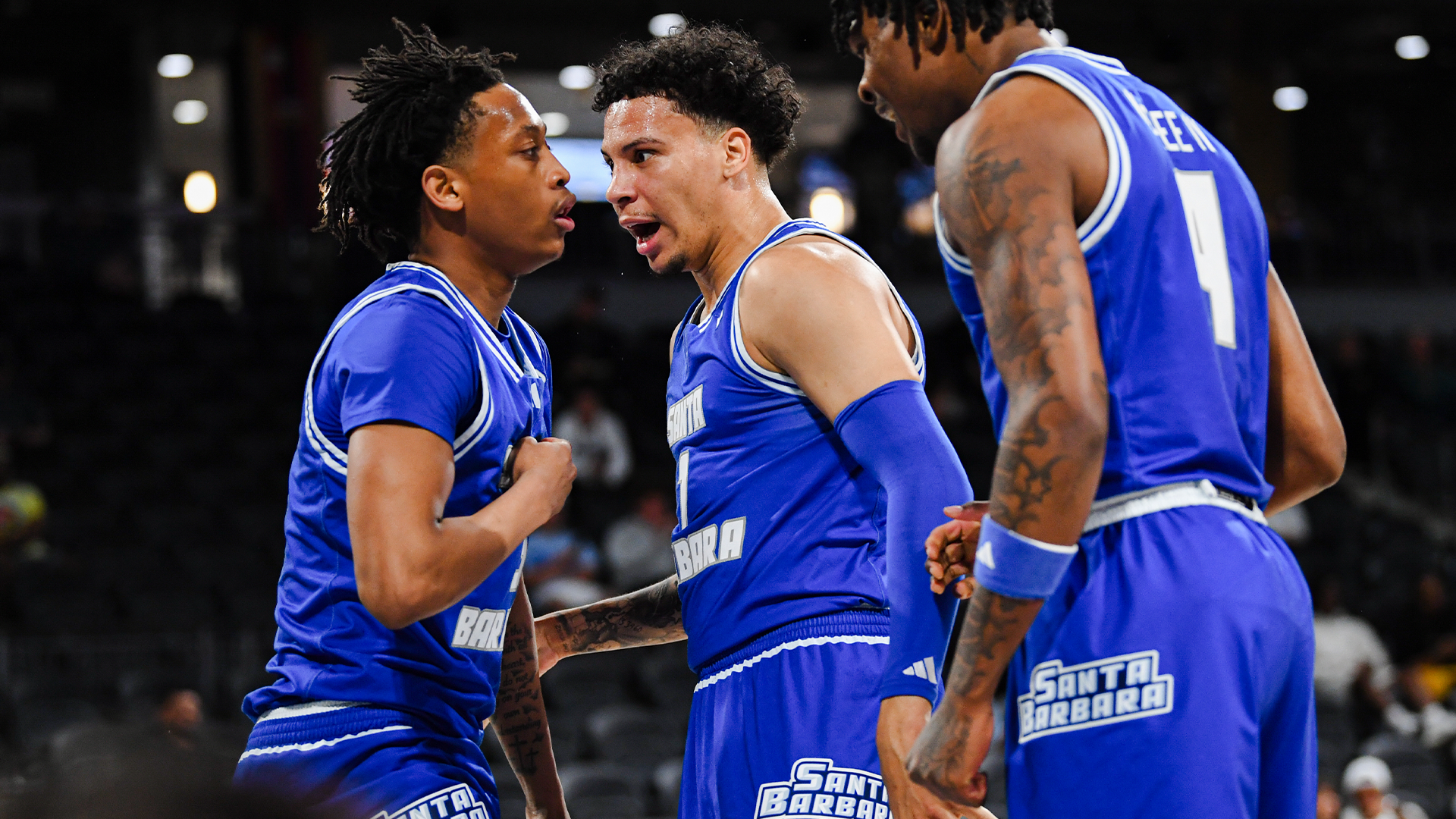 Miro Little (#1), CJ Shaw (#3) and Marvin McGhee IV (#4) celebrate by looking intensely and shouting at one another after a basket. 