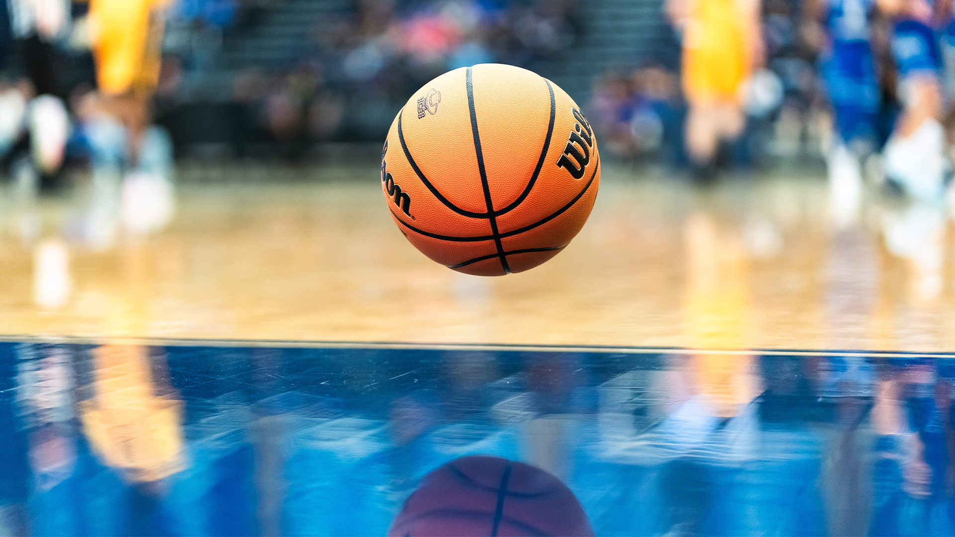 A basketball is bouncing in mid air above the floor of the thunderdome.