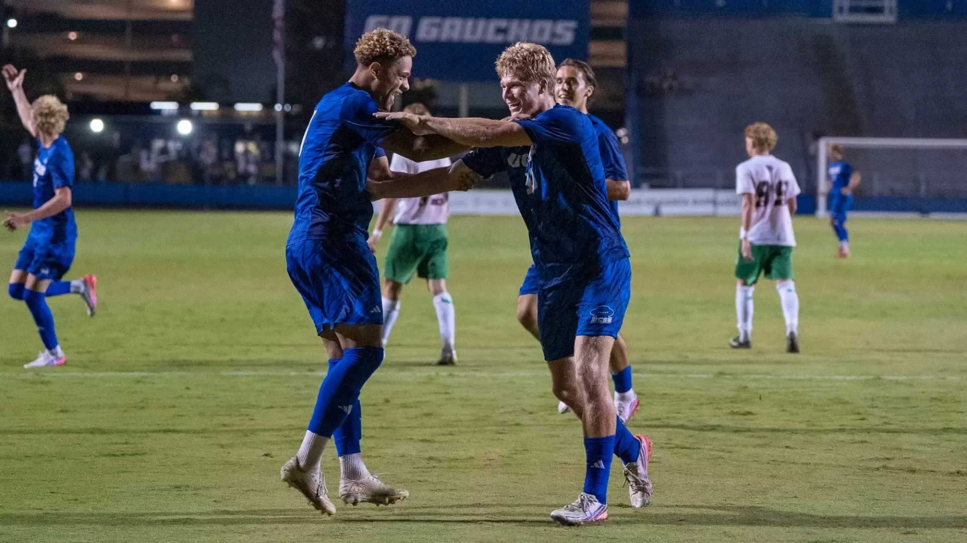 Donovan Sessoms and Zac Siebenlist smile as they grab each other by both shoulders in celebration after Sessoms scored the penalty kick that Siebenlist earned
