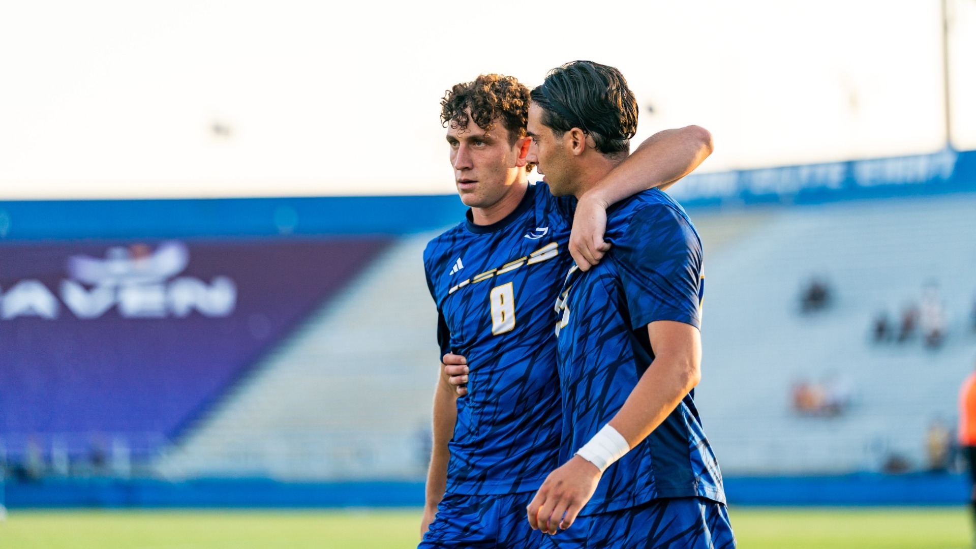 #8 Peleg Brown wraps his left arm around the shoulders of his fullback partner, Simone Ferrieri before a game at Harder Stadium.