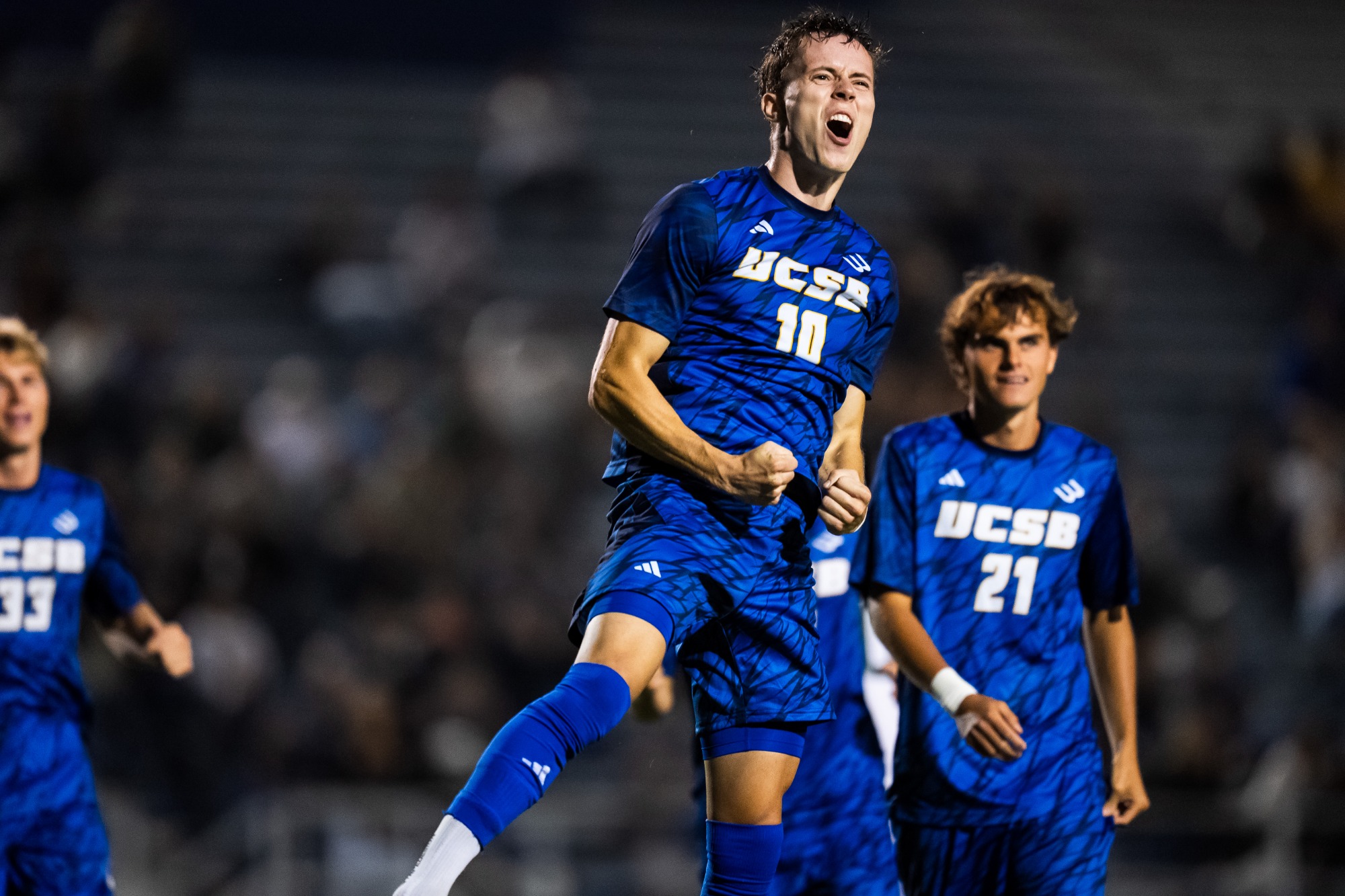 #10 Steinar Bjornsson celebrates his goal in the air with teammates in the background.