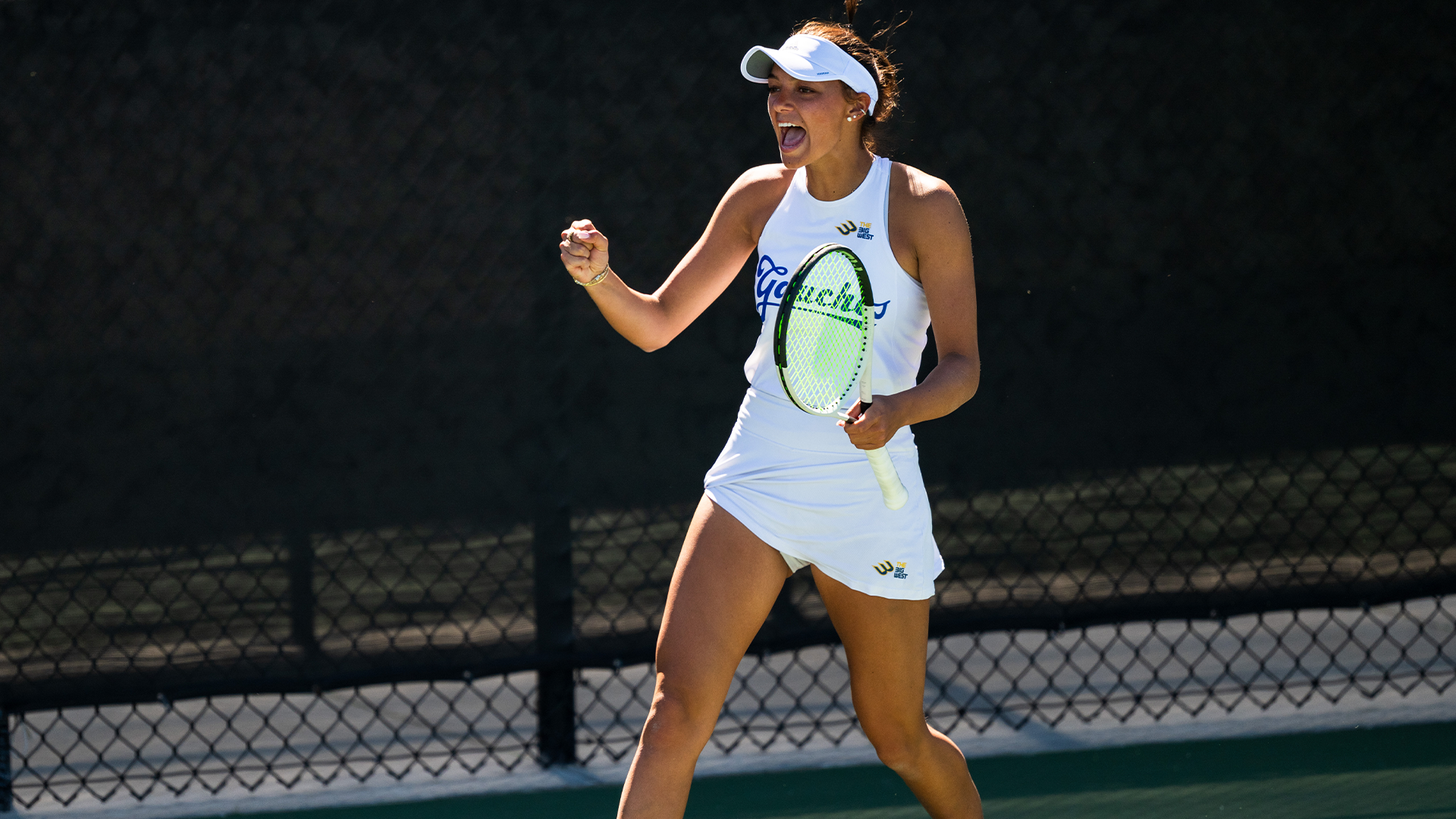Sophomore Emma Tutoveanu celebrates a point by fist pumping with her right hand and holding her racquet in her left hand.