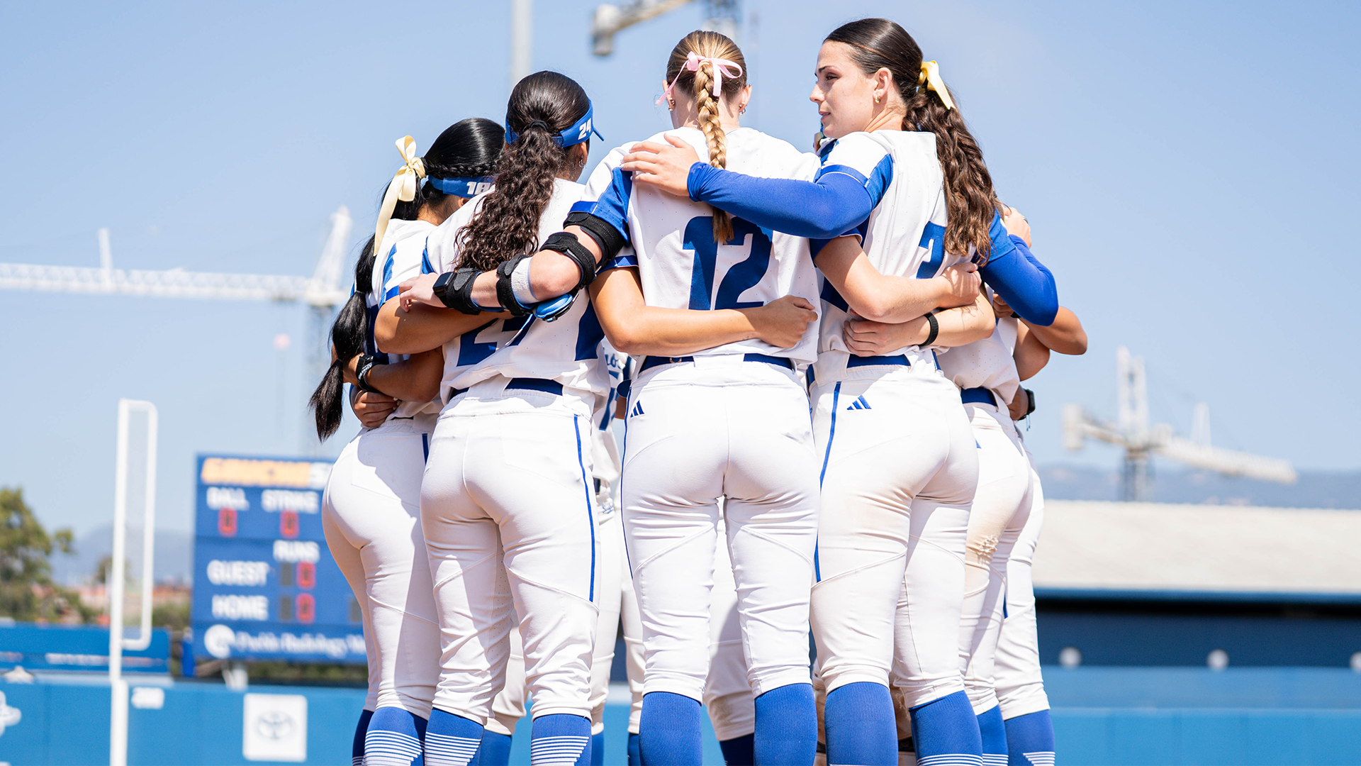 The UC Santa Barbara starting lineup huddles up prior to the game, putting their arms around one another waiting for their name to be announced before running out to the field.