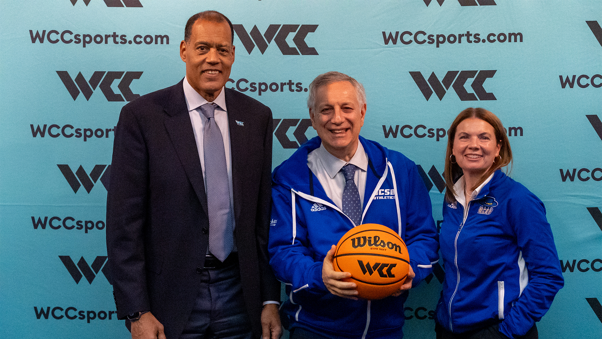 WCC Commissioner Stu Jackson, UCSB Chancellor Dennis Assanis and Arnhold Director of Athletics pose following a press conference in front of the WCC backdrop.