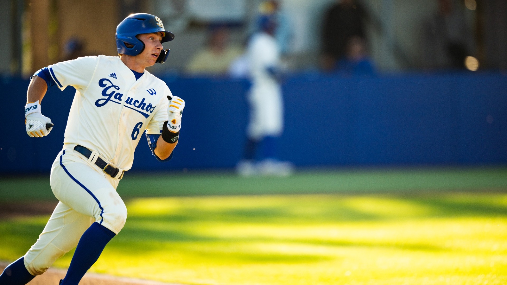 #6 Nick Husovsky looks up as he sprints around first base in the evening light.