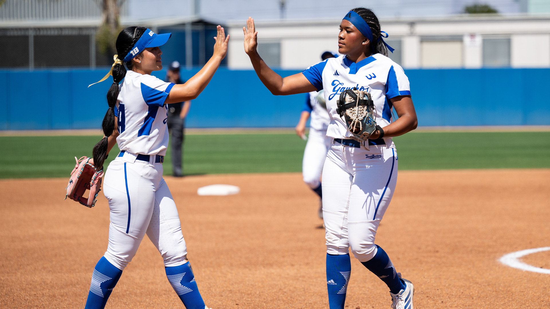 Malaya Johnson (#55) and Bella Fuentes (#18) high five each other after an out was recorded.