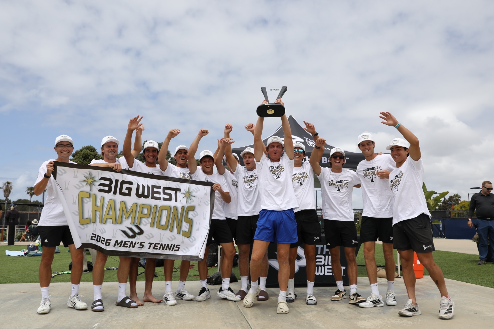 Men's Tennis celebrates with trophy and banner after winning the Big West Championships