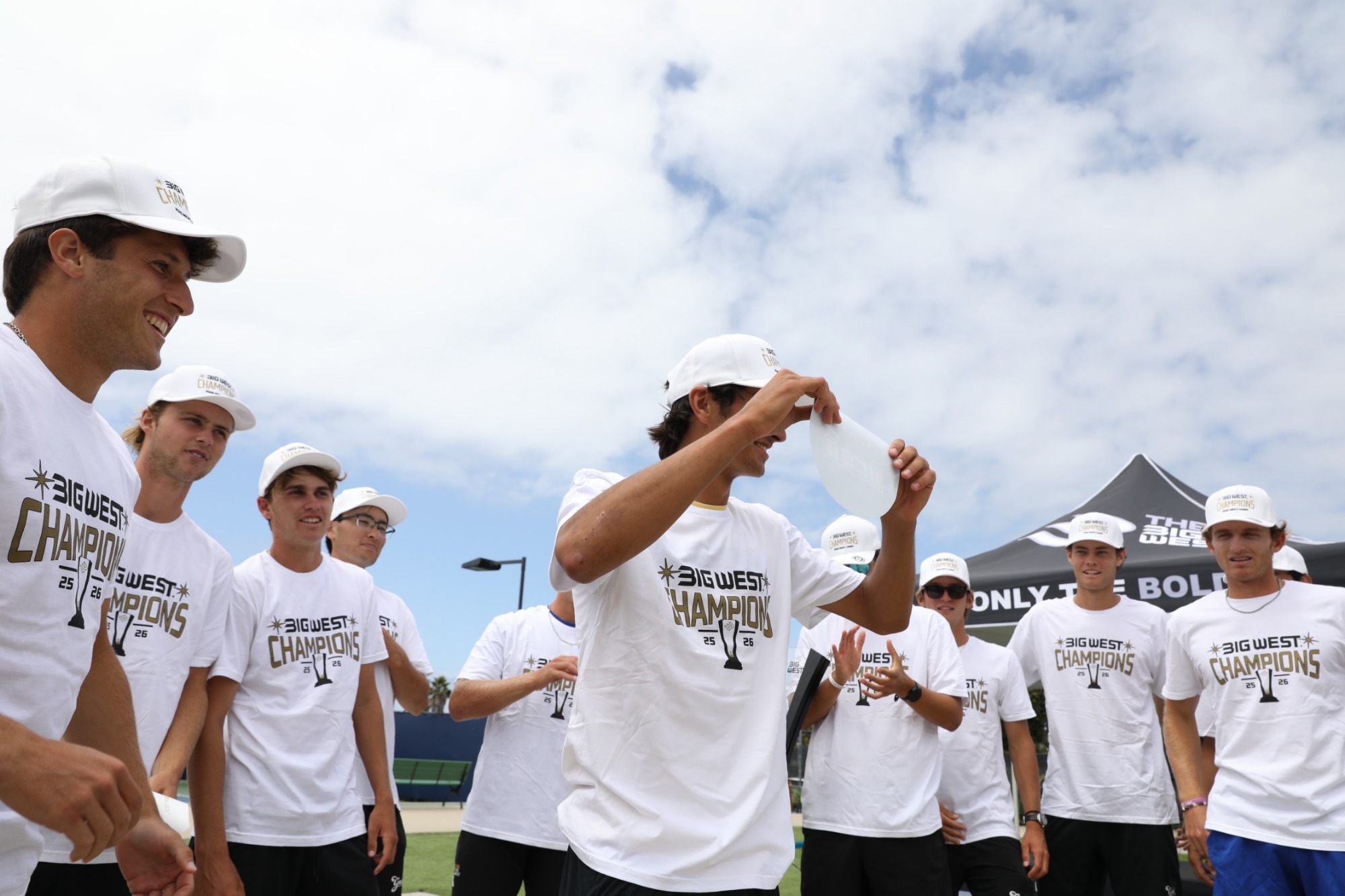 Diogo Morais is about to place the UCSB sticker on the bracket after clinching in the Big West Championship finals with his team surrounding him