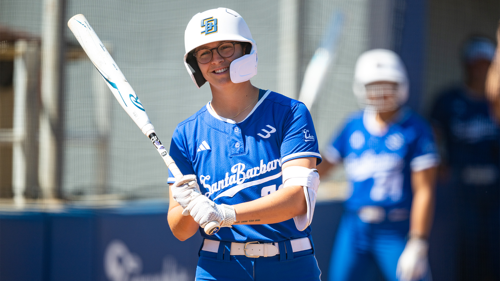 Daryn Siegel (#33) gets ready to step into the batters box with her bat held by her side and smiling.