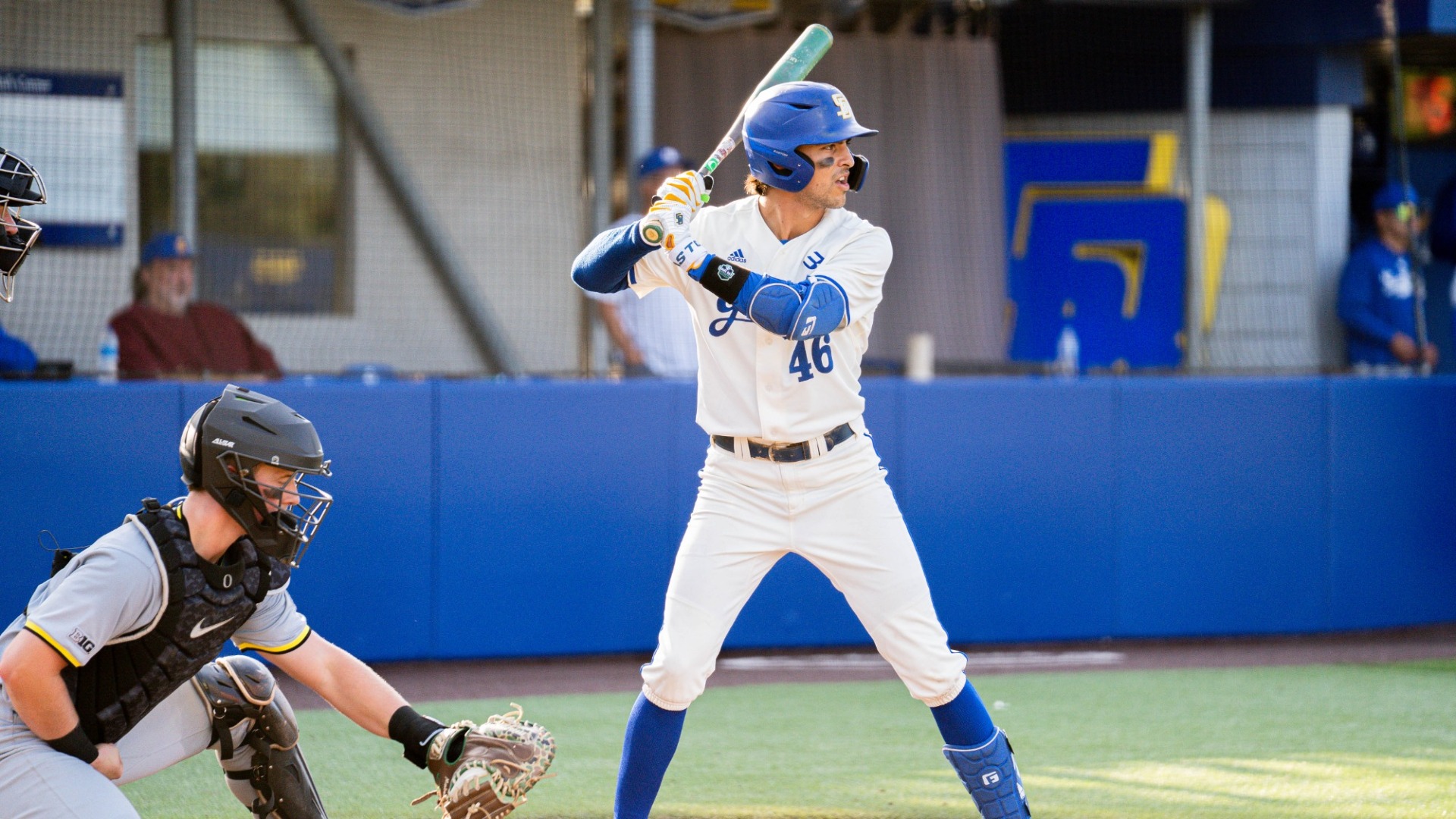#46 Ryan Severns stands tall in the batter's box. He rests his bat on his shoulder and prepares to hit.