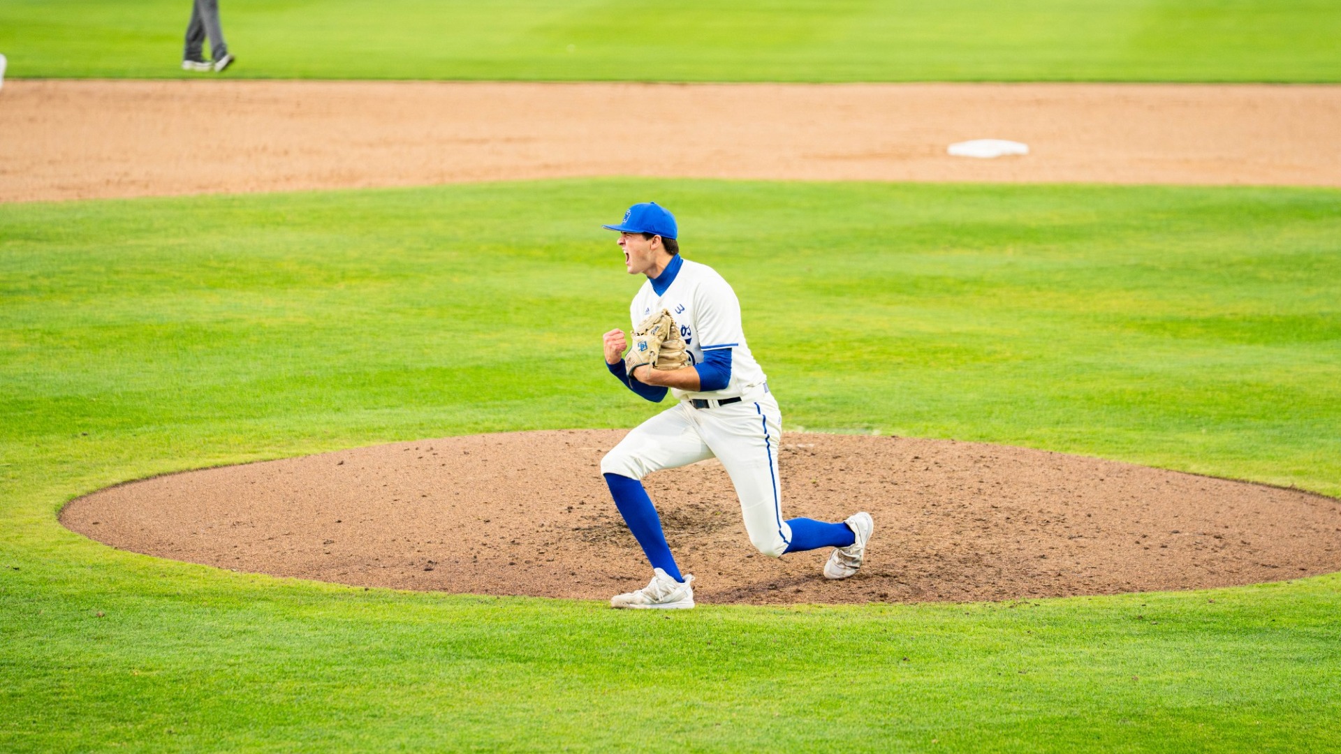 #2 Jackson Flora pumps both fists and yells in celebration as he comes off the pitching mound at Caesar Uyesaka Stadium. 