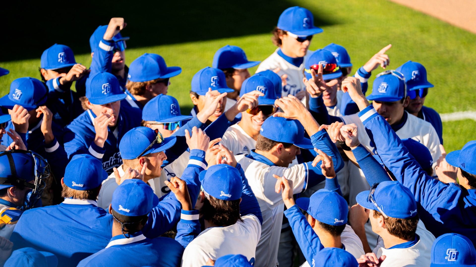 Gaucho Baseball players huddle around Jackson Flora as they prepare to take the field.