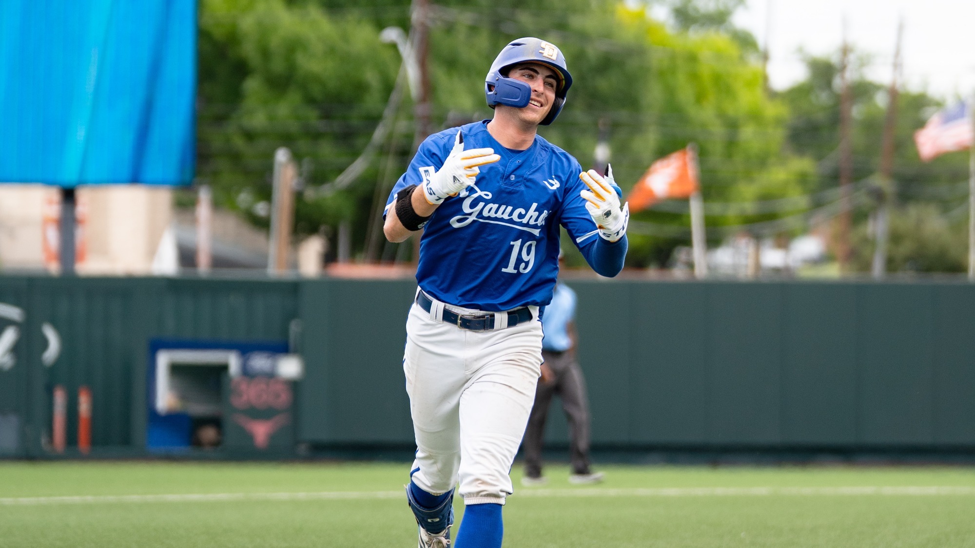 Cole Kosciusko smiles and flashes finger guns as he rounds third base after hitting a home run in the NCAA Austin Regional