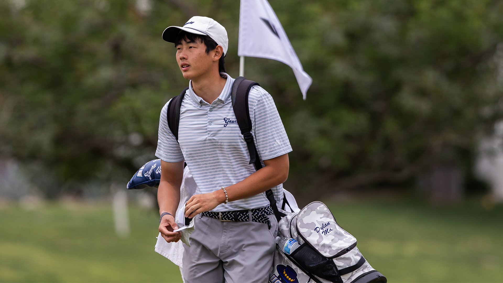 Dylan Ma finishes a hole and walks off the green while glancing at the sky.
