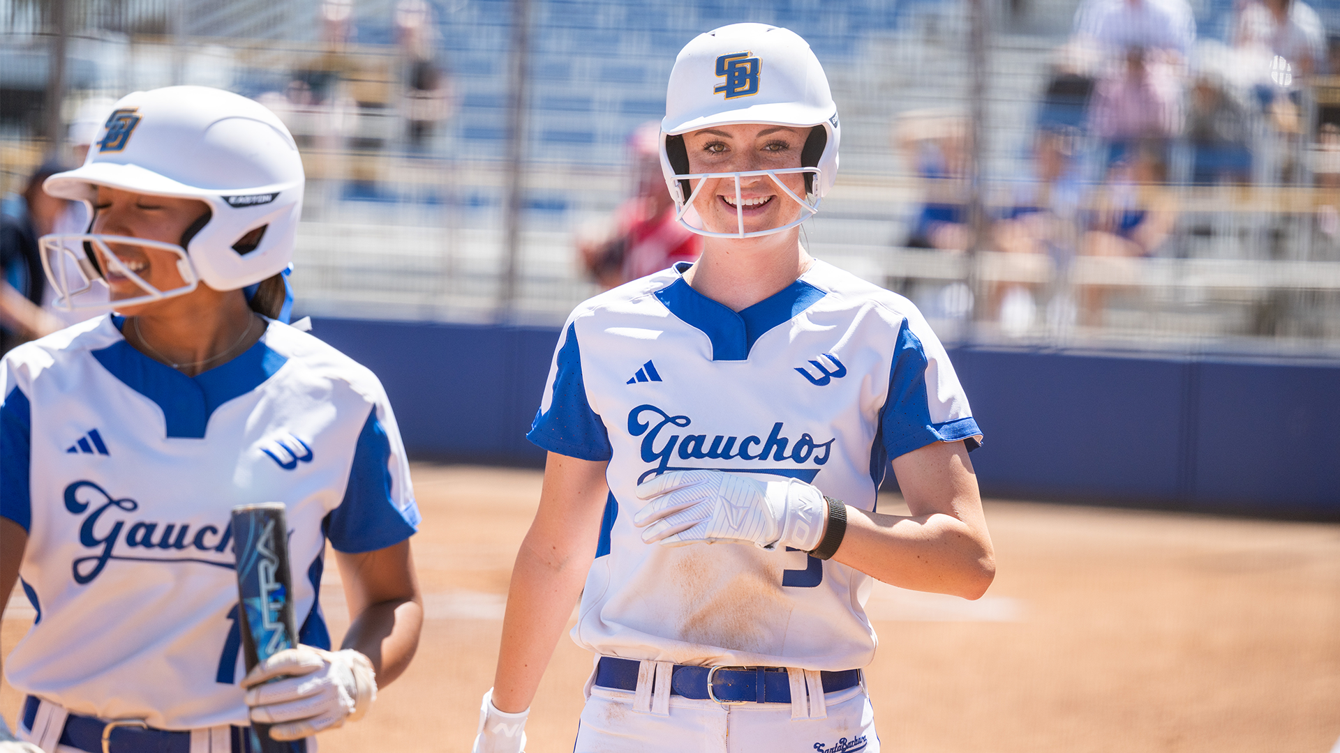 Dani Rauscher (#5) celebrates with Tehya Banks (#1) after scoring and heading back to the dugout. 
