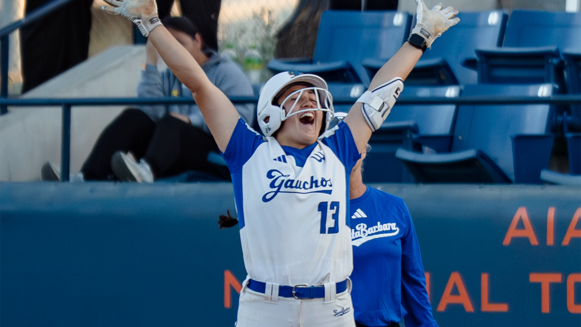 Ella Myers (#13) stands with her arms to the sky, celebrating her walk off hit against UC San Diego in the first round of The Big West Championships.