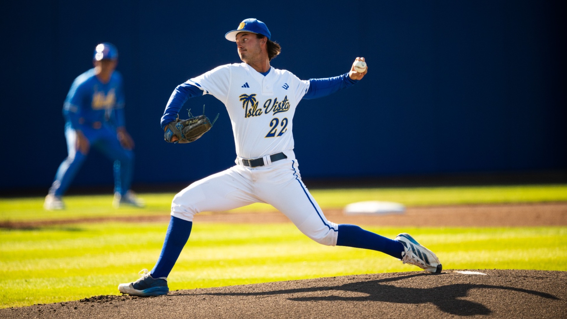 #22 Chase Hoover lunges into his pitch delivery. We have a side-on view as Chase has his left hand cocked up at a right angle behind him, his glove hand cocked down at the same angle in front of him.