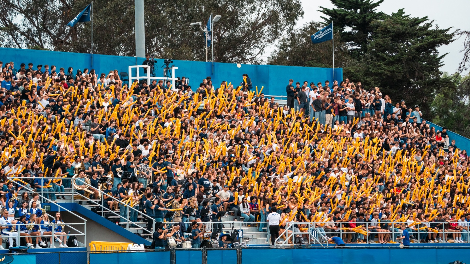 A shot of the student section at Harder Stadium during the Blue-Green Rivalry game. The stands are a sea of golden Thundersticks