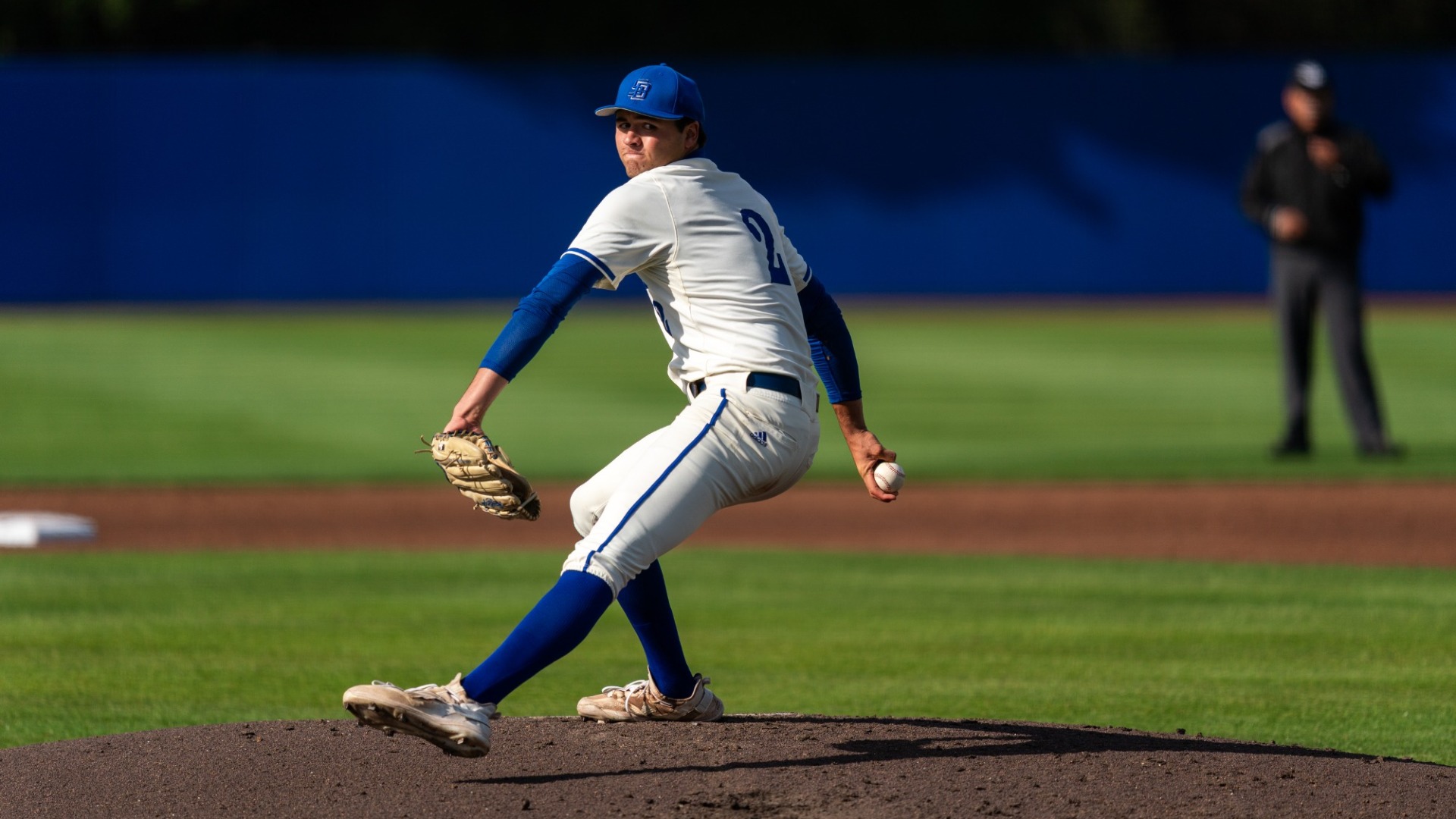 A view from behind home plate as Jackson Flora steps into his pitch delivery from the mound at Caesar Uyesaka Stadium
