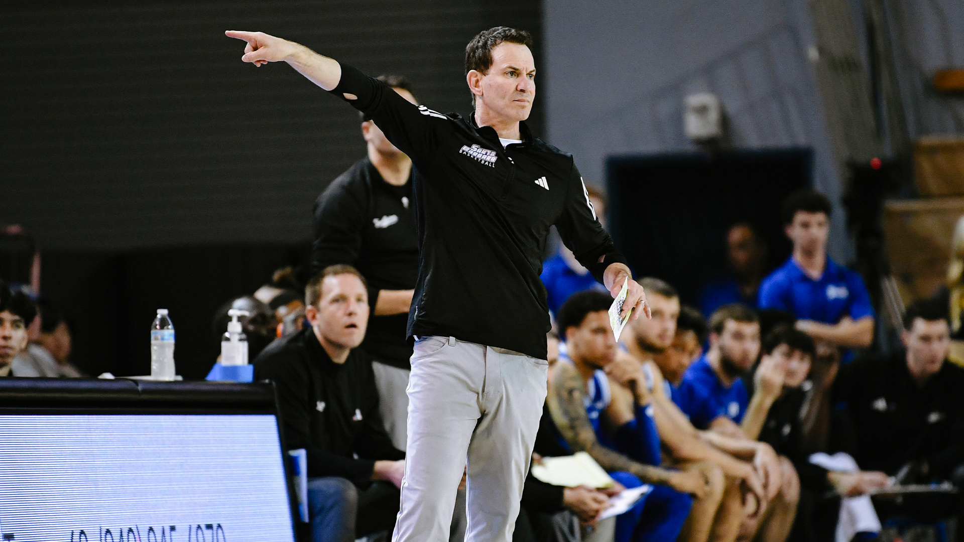 Head Men's Basketball Coach Joe Pasternack points the Gaucho offense into direction on the sideline.