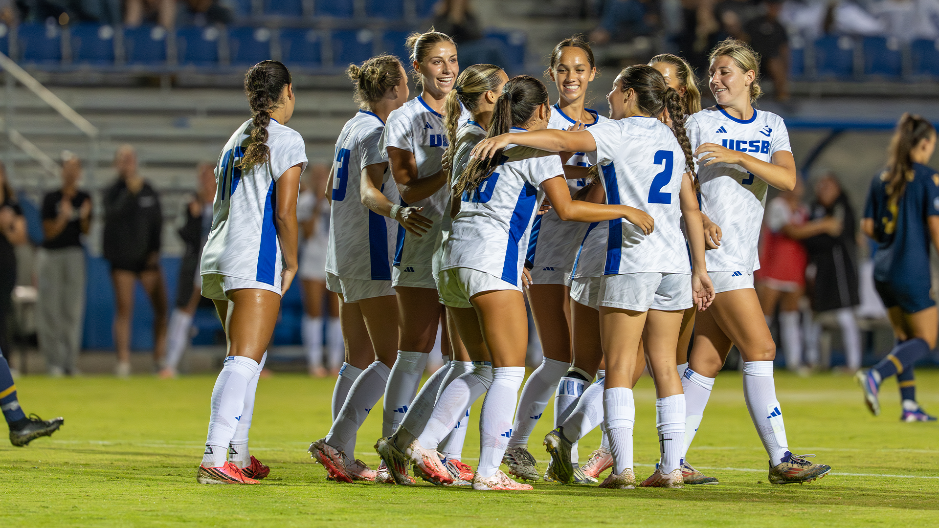 Players celebrate the second goal against Trinity Western by hugging and smiling eachother.