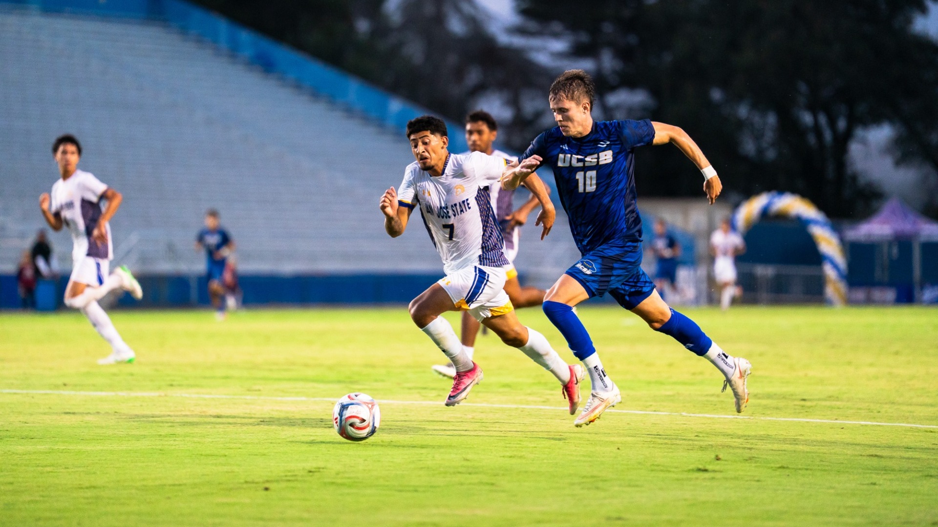 #10 Steinar sprints past a San Jose State player, dribbling the ball in front of himself