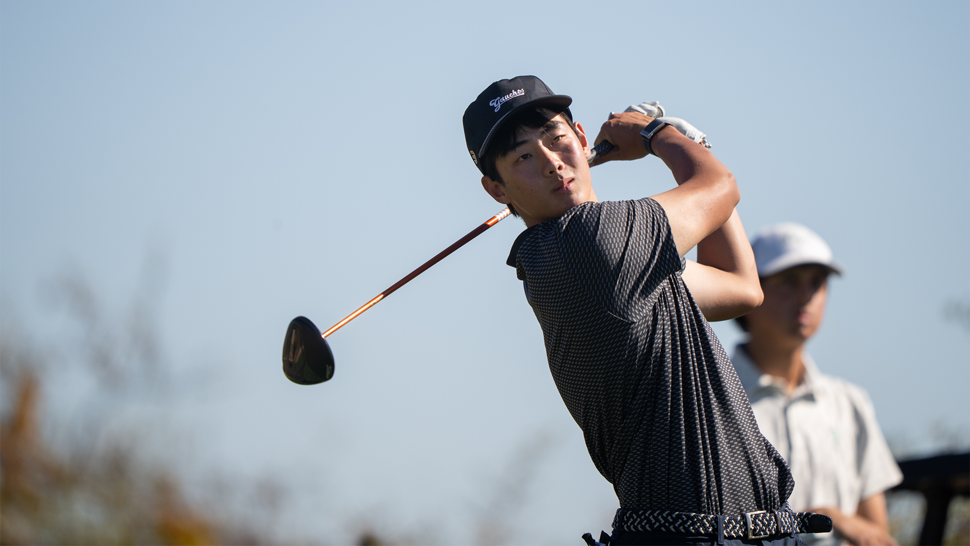 Dylan Ma finishes his swing and watches the ball in flight. 